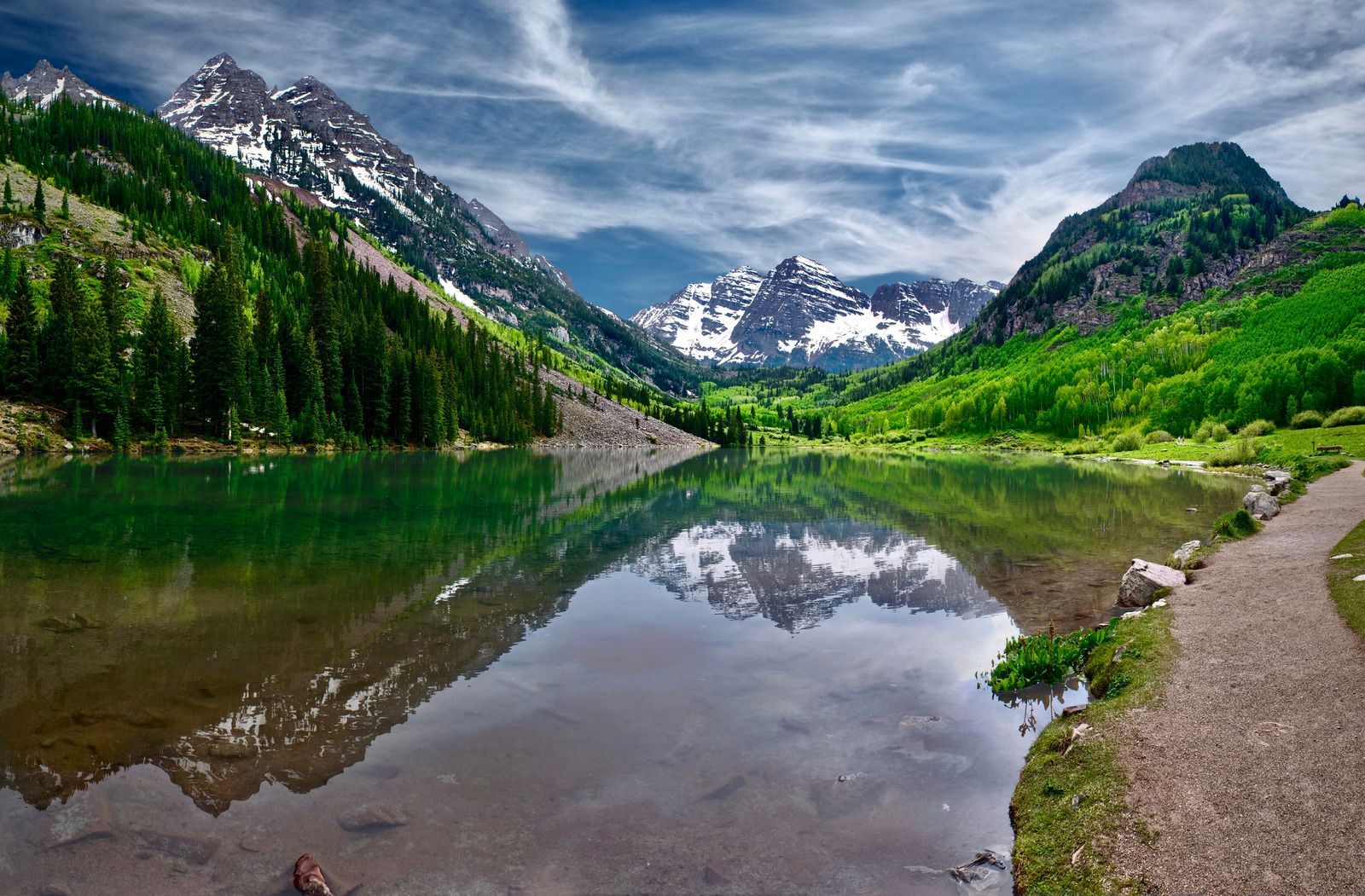A lake with mountains in the background and trees on the shore