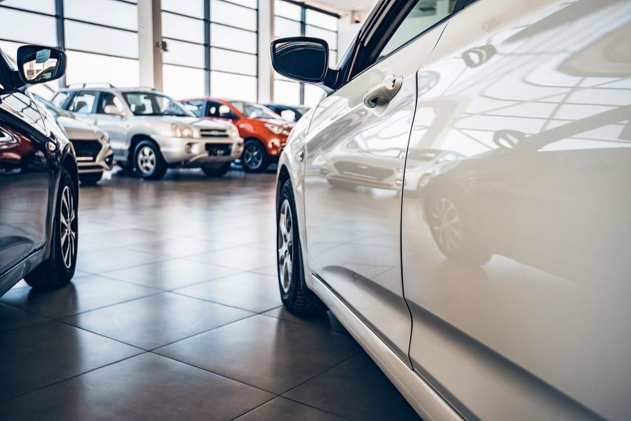 Una fila di auto è parcheggiata in uno showroom.