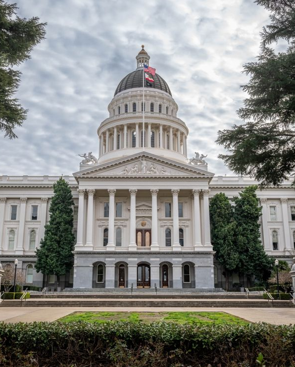 California State Capitol building with a large dome under a cloudy sky.