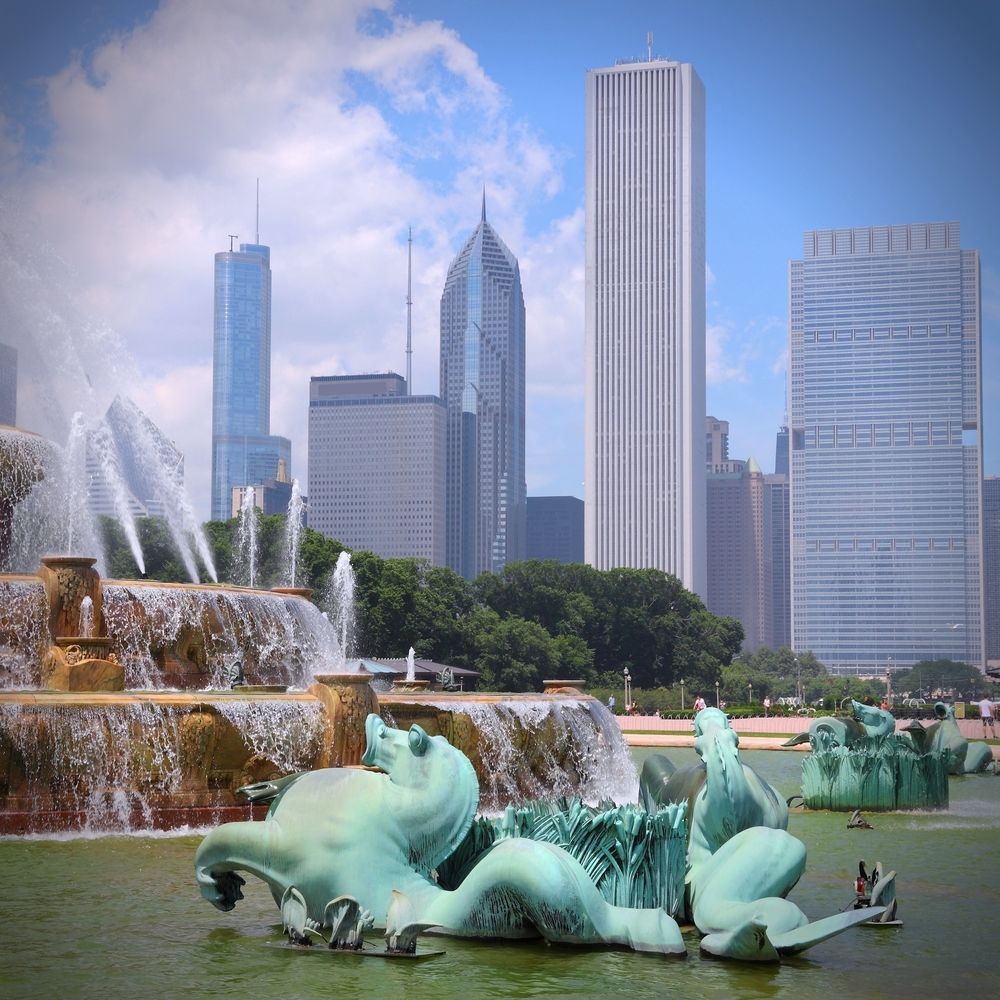 Buckingham Fountain in Chicago with skyline background. Bronze sculptures and water features.