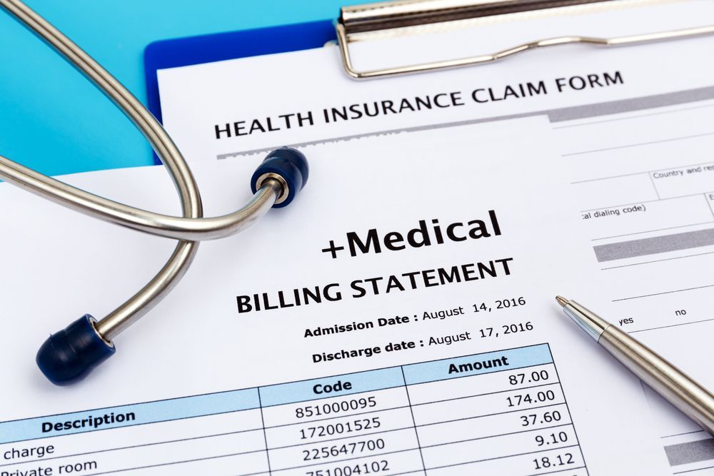 Health care cost concept with medical bill and health insurance claim form