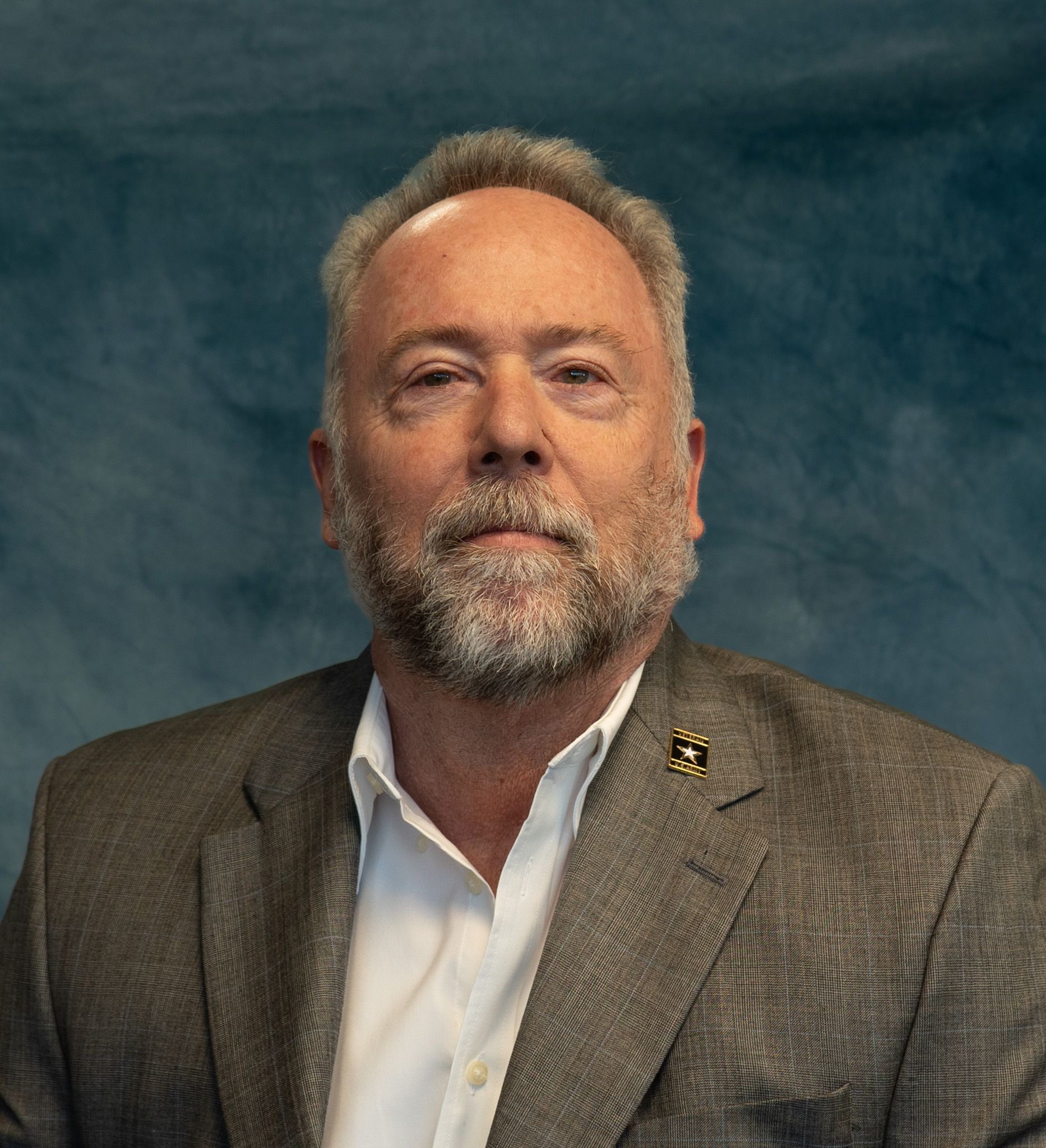 A man with a beard is wearing a suit and tie.