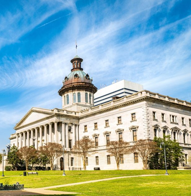 South Carolina State House in Columbia, a large white building with a copper dome under a blue sky.