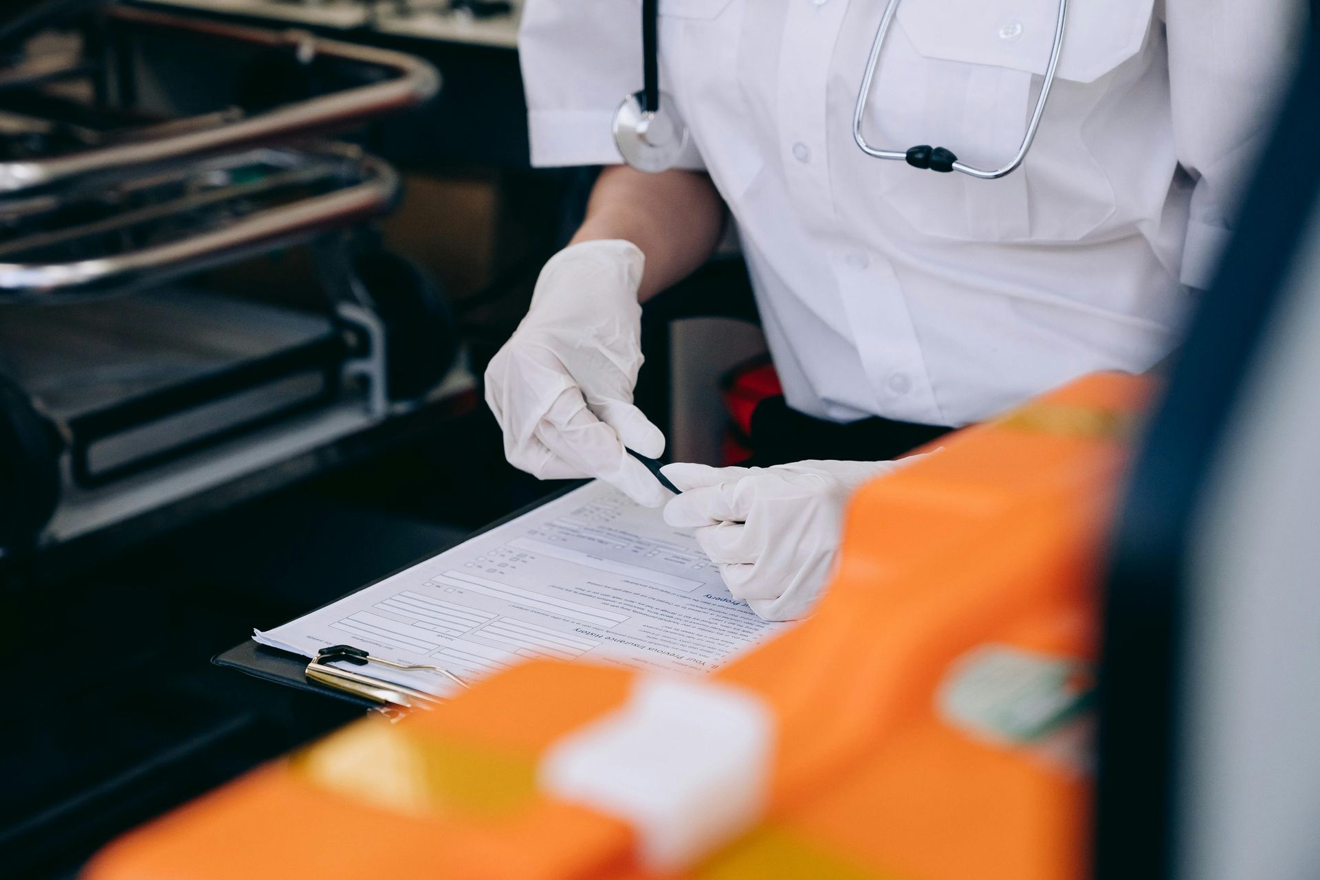 Worker in white gloves inspecting paperwork beside orange safety gear in an industrial setting