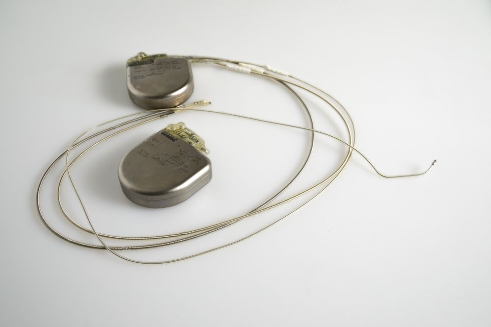 Two pieces of metal with wires attached to them on a white surface