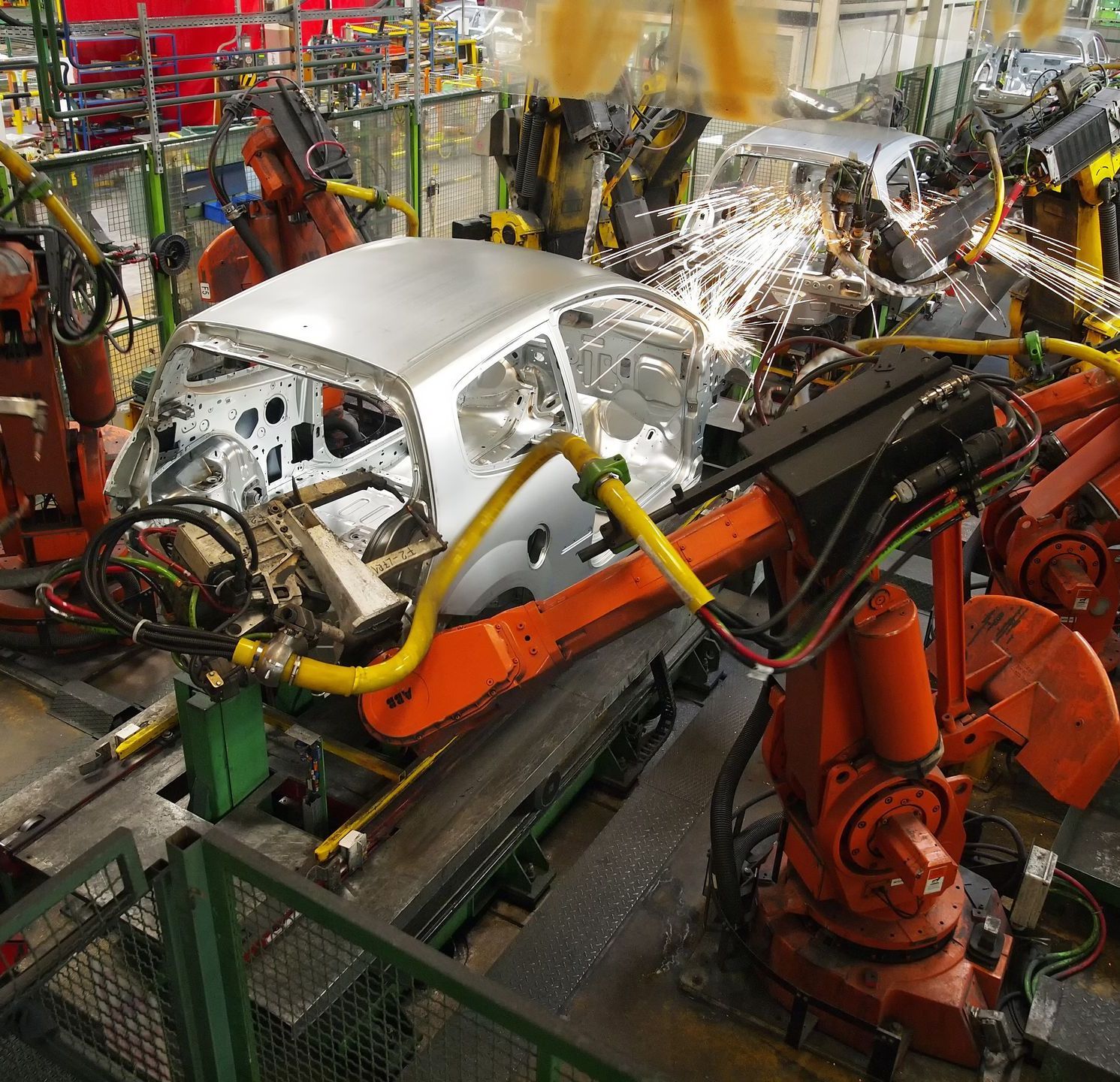 A car is being assembled by robots in a factory