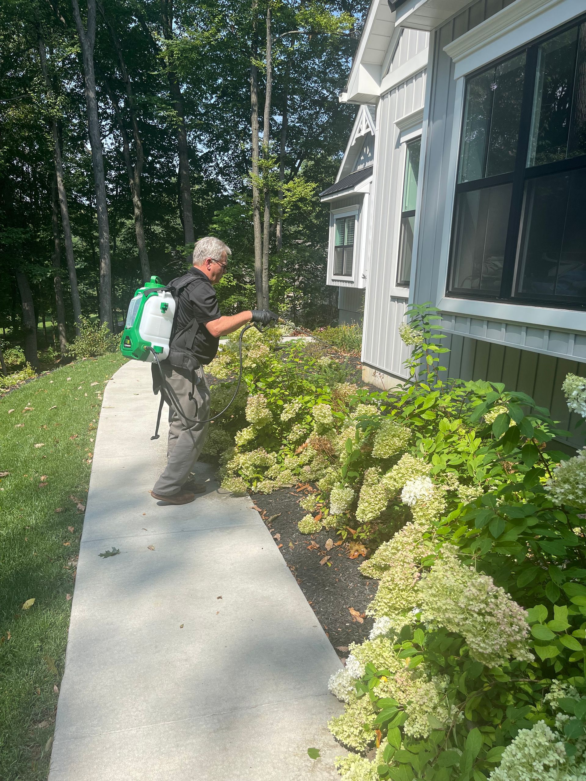 A Keystone Pest Solutions technician inspecting the exterior perimeter of a Lancaster County home.