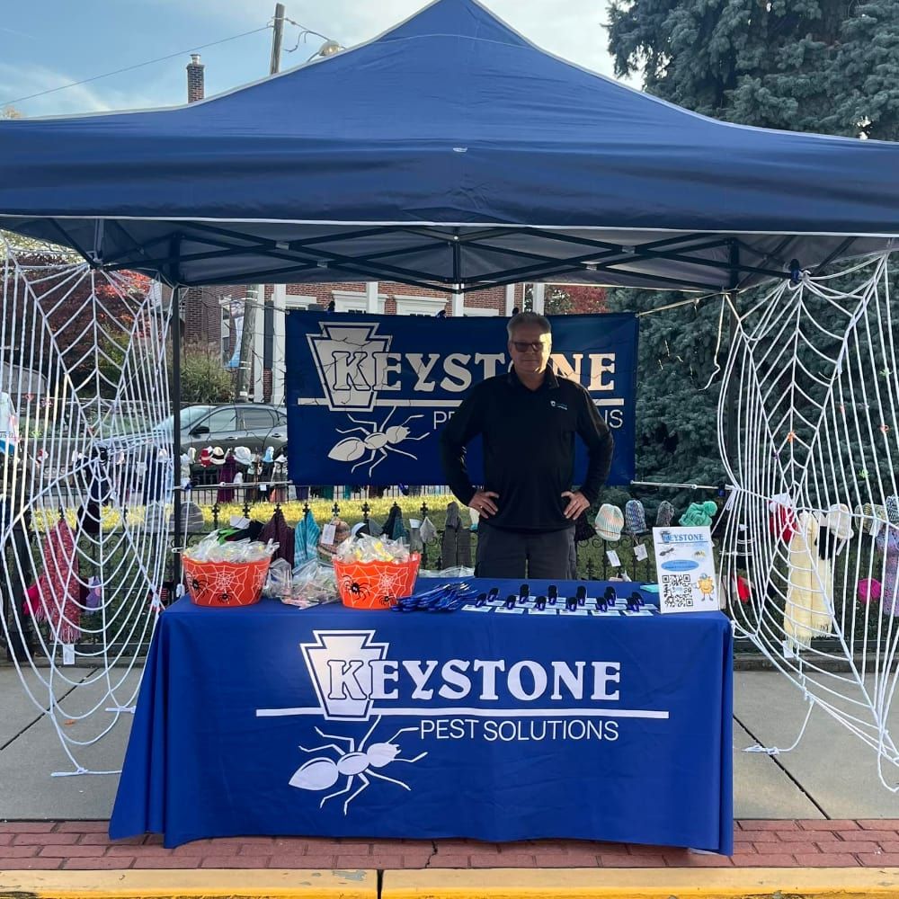 A man stands in front of a table that says keystone pest solutions