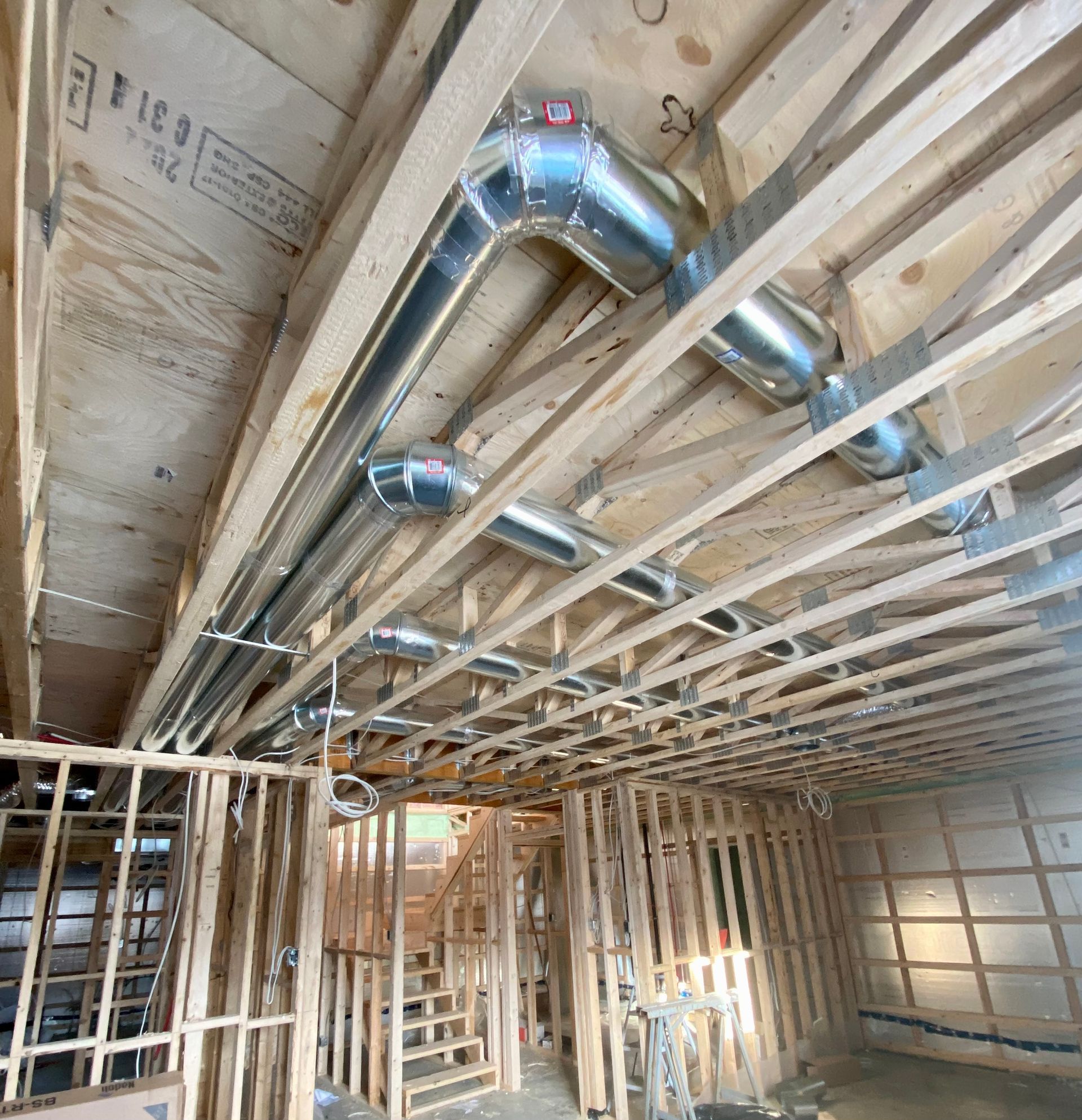 Une pièce en construction avec beaucoup de tuyaux sortant du plafond.