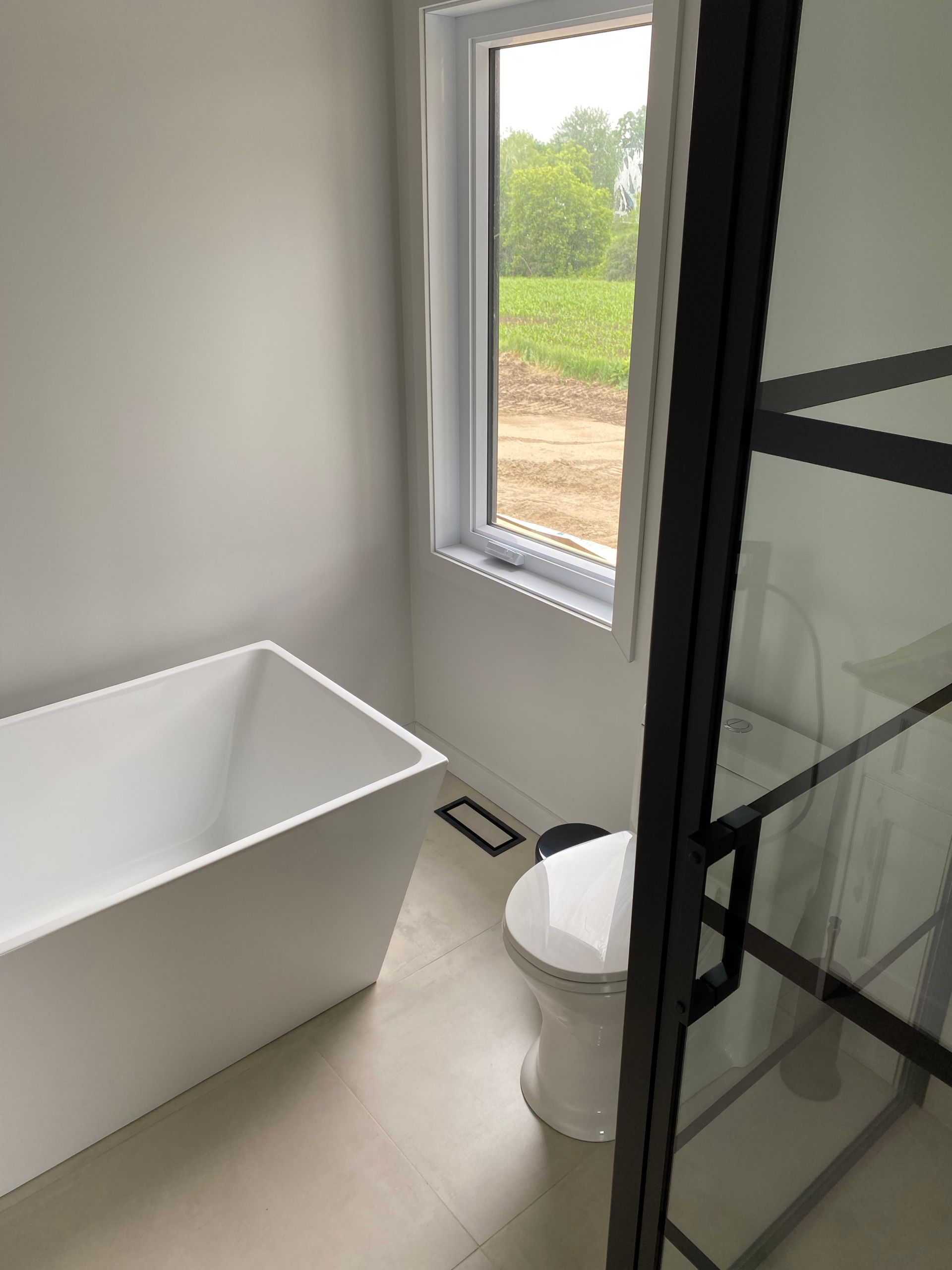 Une salle de bain avec baignoire, WC et fenêtre.