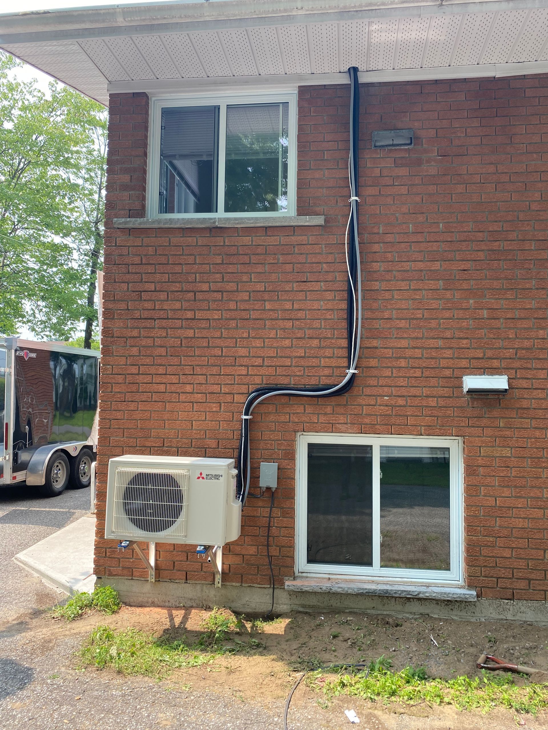 Un bâtiment en briques avec un climatiseur fixé sur le côté.