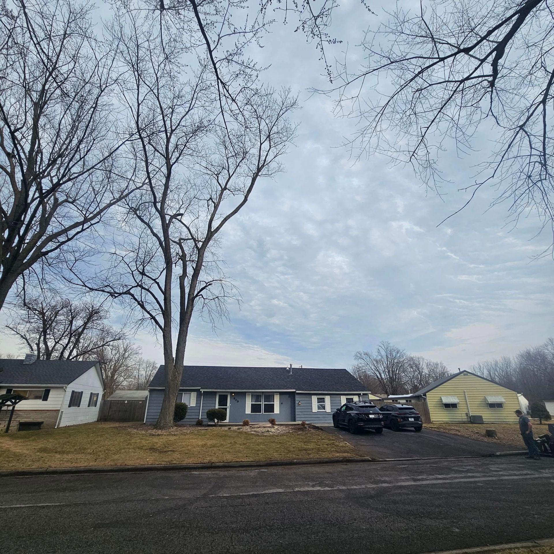 A couple of cars are parked in front of a house