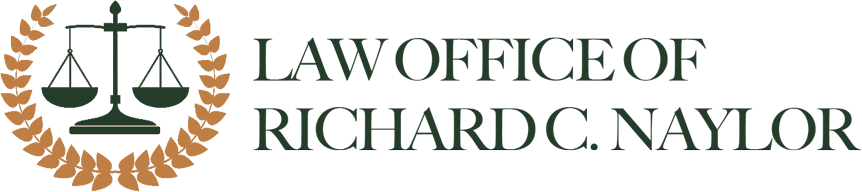 Law Office of Richard C. Naylor logo: scales of justice within a laurel wreath, with text.