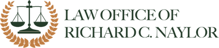 Law Office of Richard C. Naylor logo: scales of justice within a laurel wreath, with text.