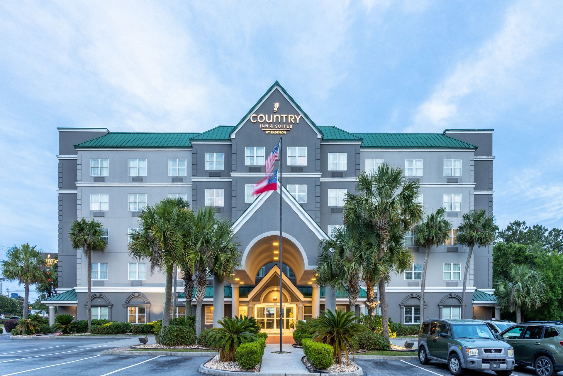 Exterior with palm trees of Country Inn and Suites in Valdosta, GA.