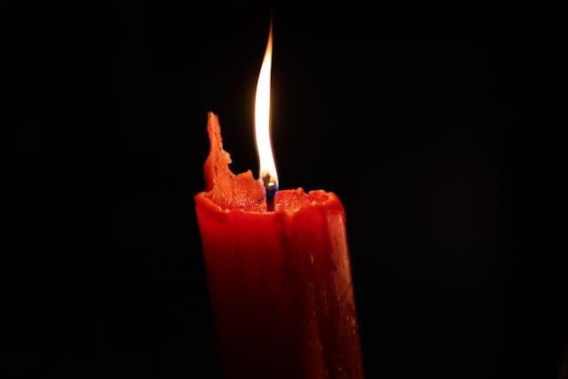 red memorial candle flame symbolizing remembrance and closure for cremation services Bedford Park IL