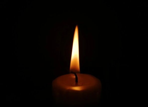 Single lit candle in a dark setting symbolizing remembrance and reflection in Chicago, IL.