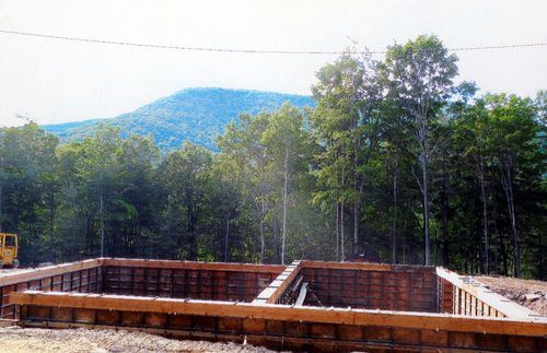 Wooden formwork for a foundation, with trees and a mountain in the background.