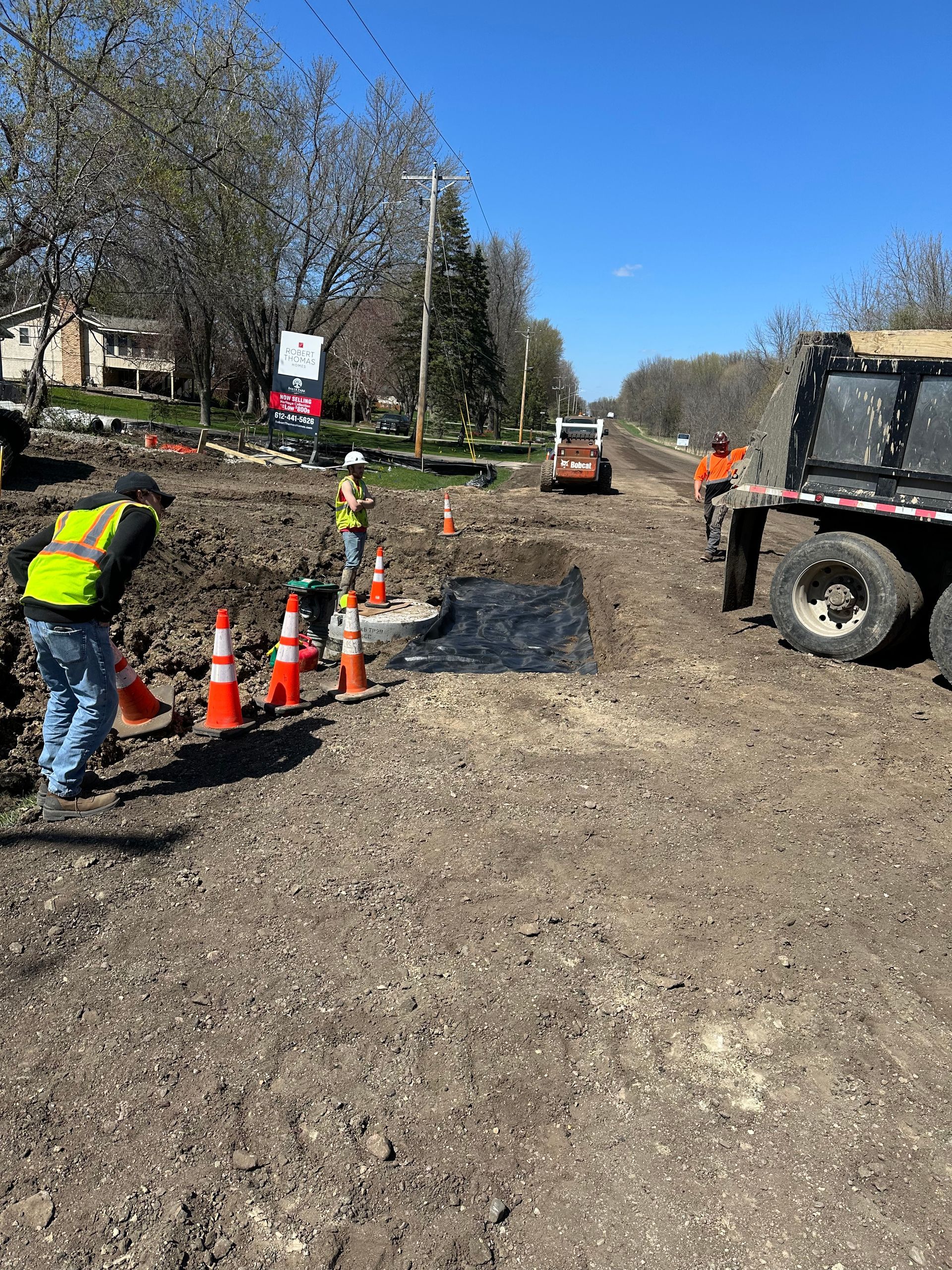A group of construction workers are working on a road.