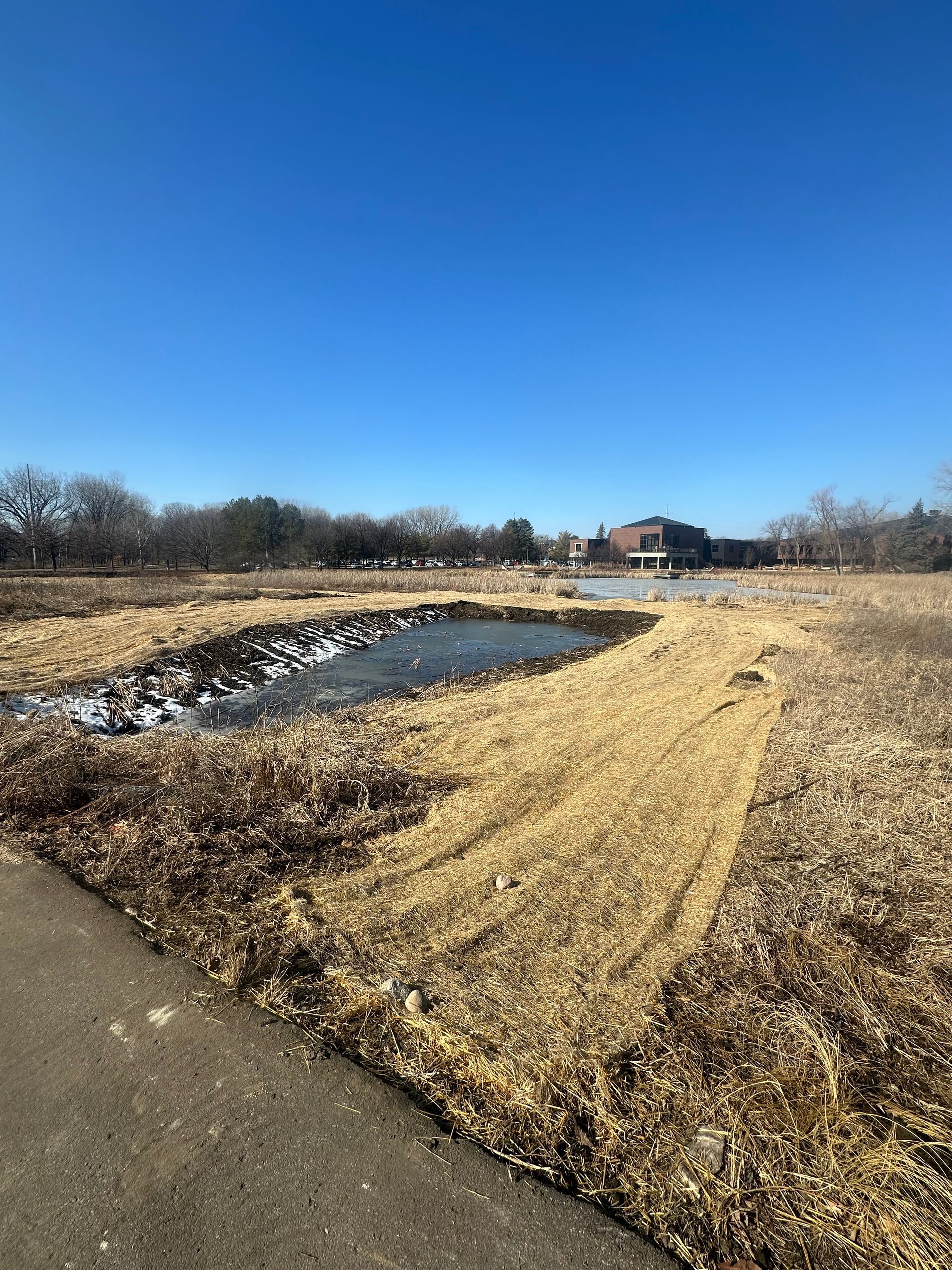 There is a large body of water in the middle of a field.