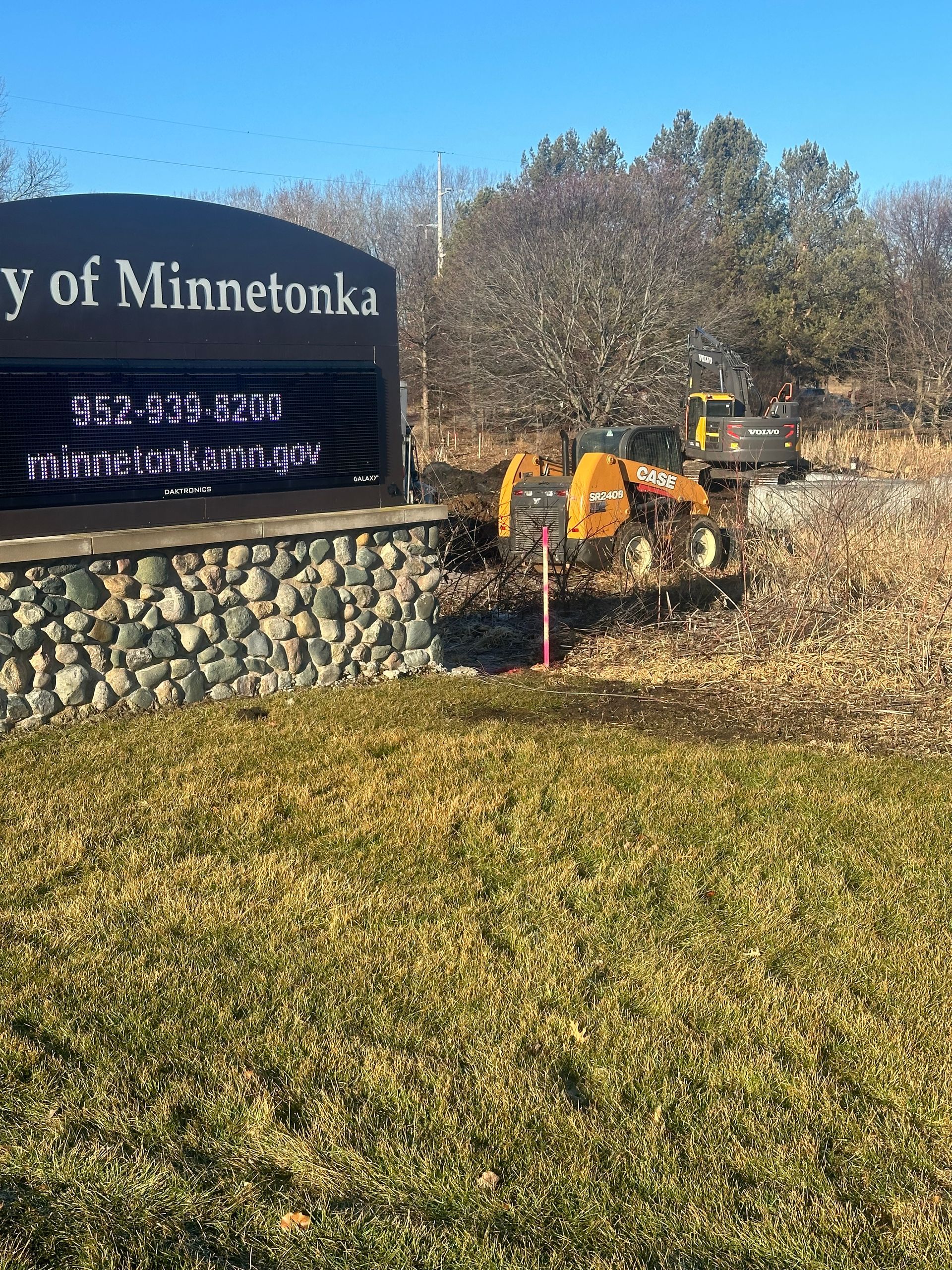 A sign for the city of minnesota is sitting in the middle of a grassy field.