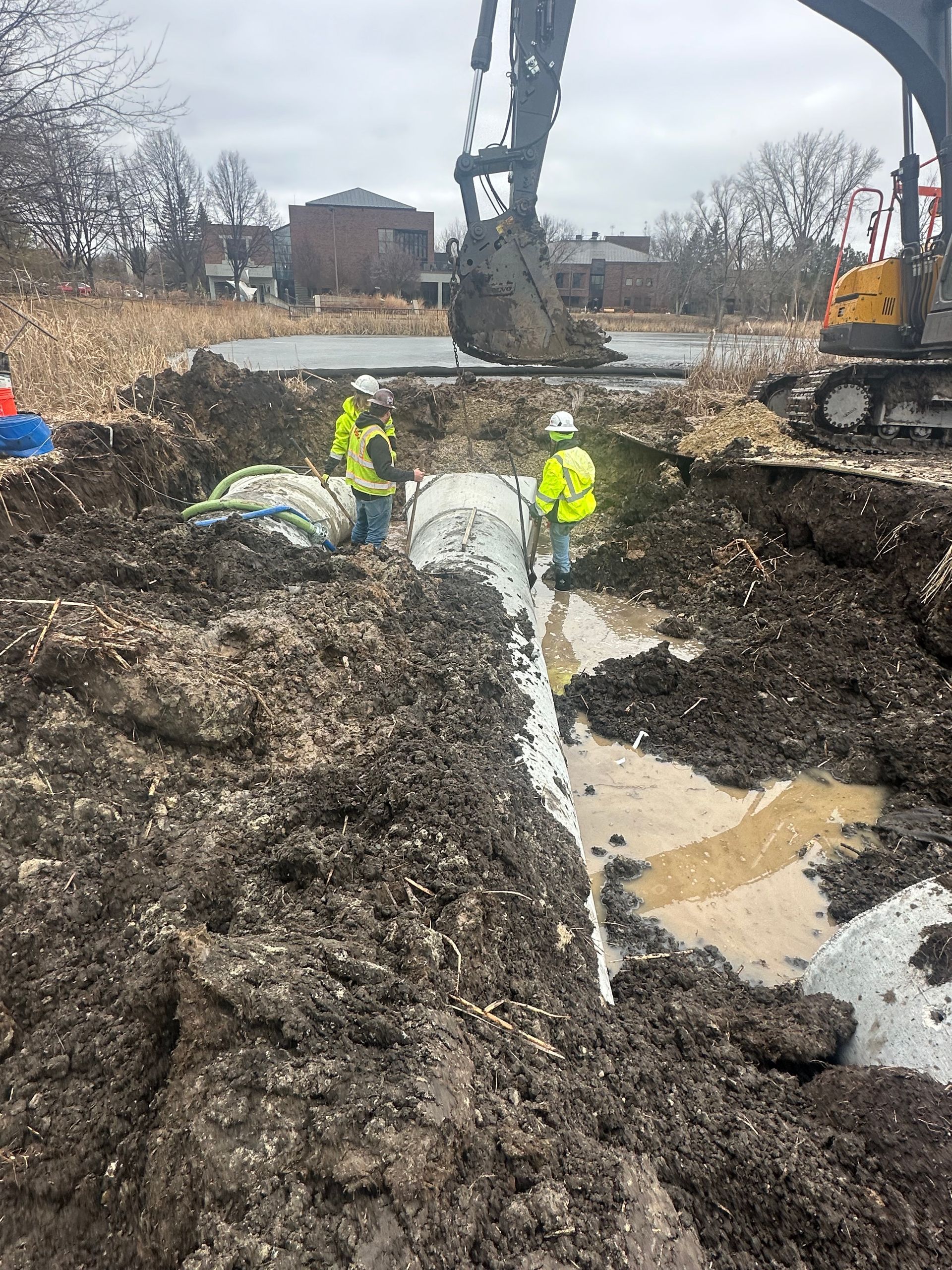 A group of construction workers are working in a muddy field.