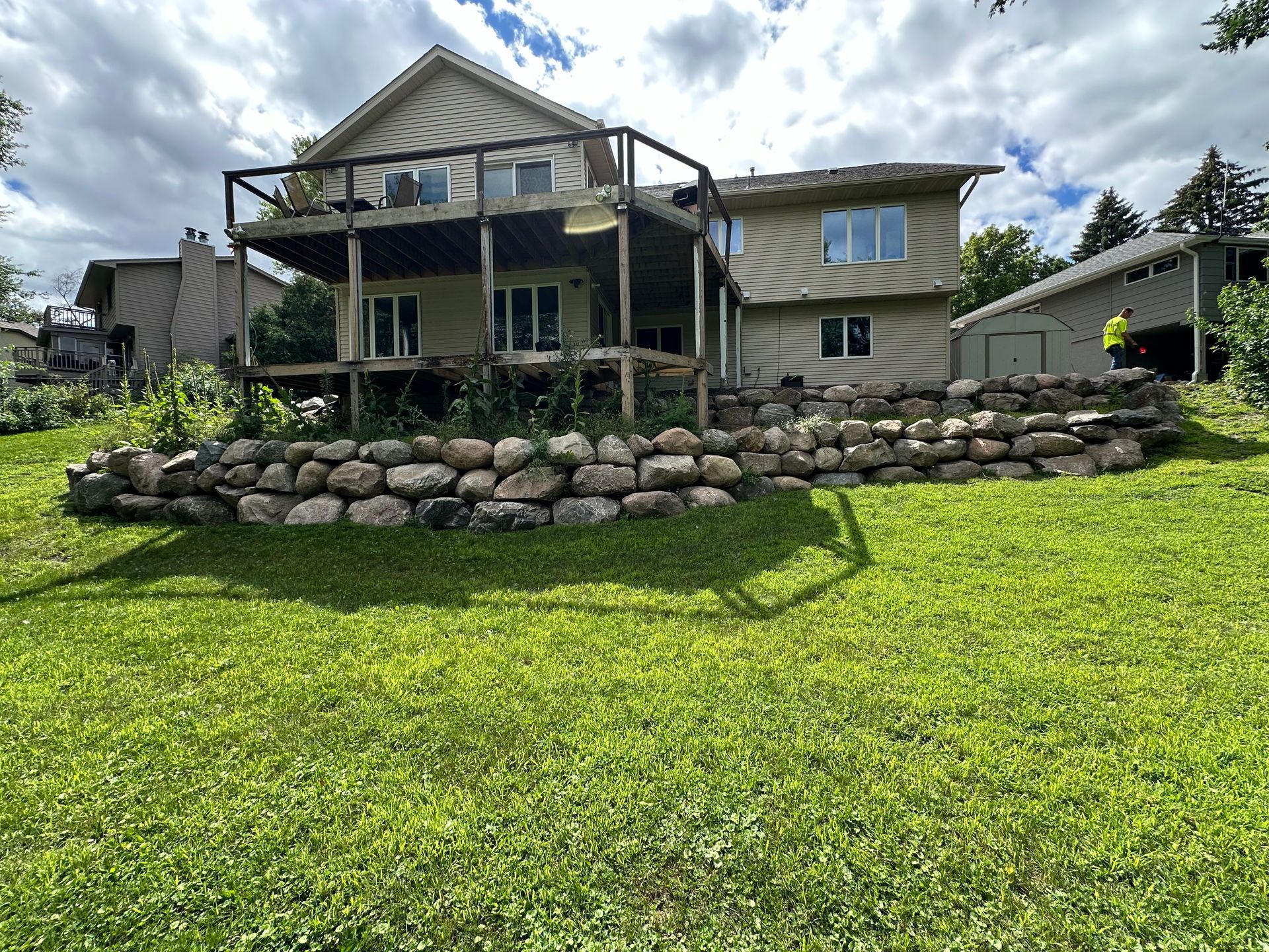 A large house with a stone wall in front of it.