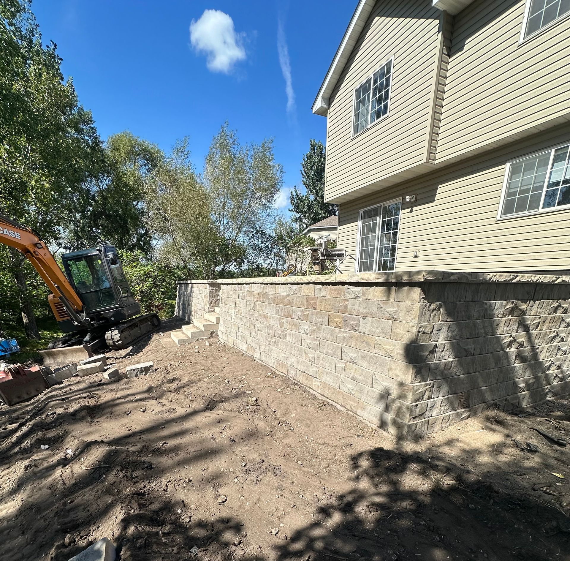 A large house with a brick wall in front of it