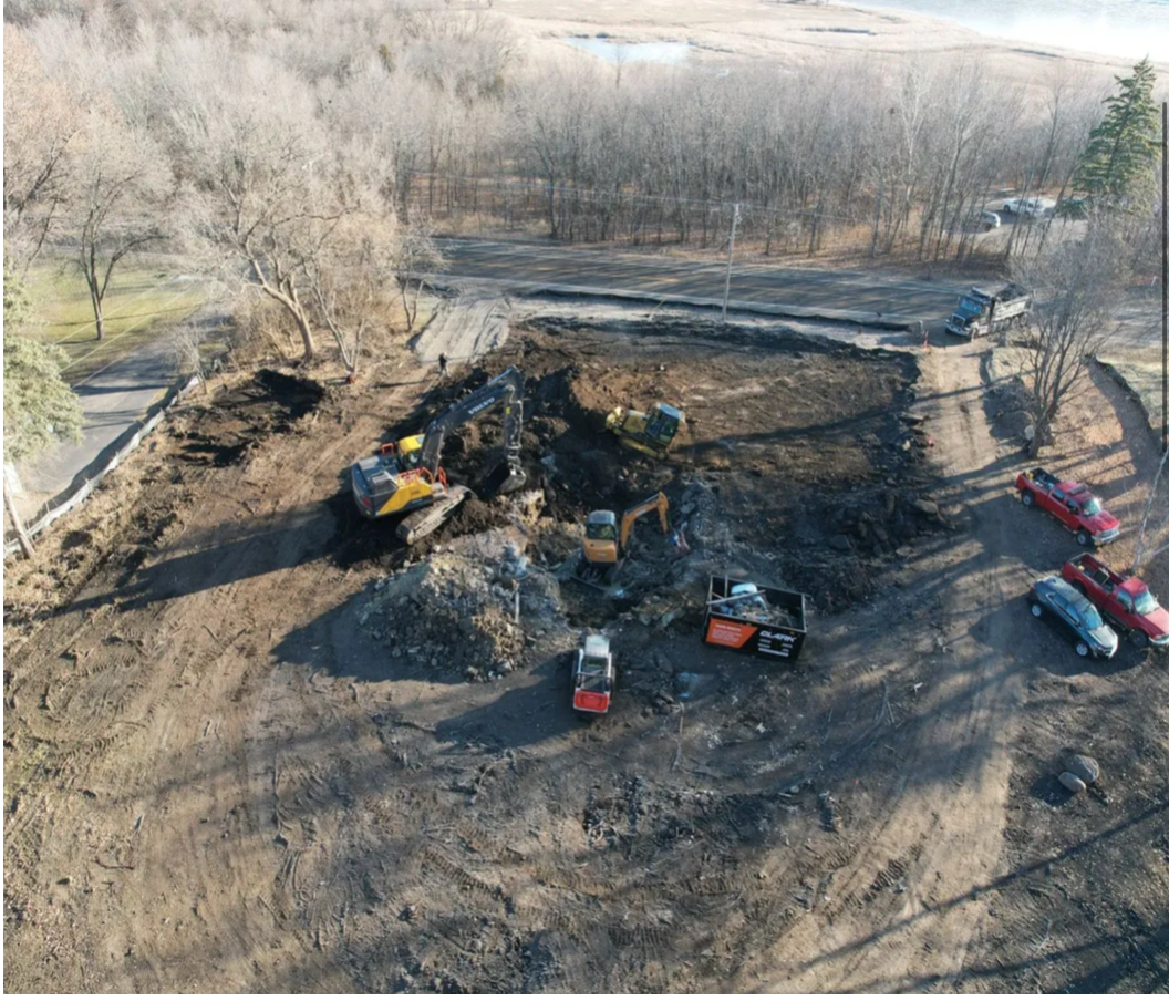 An aerial view of a construction site with trucks and tractors