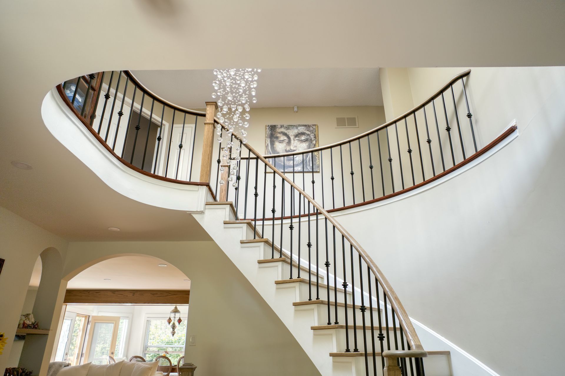 A curved staircase with a wrought iron railing in a house.