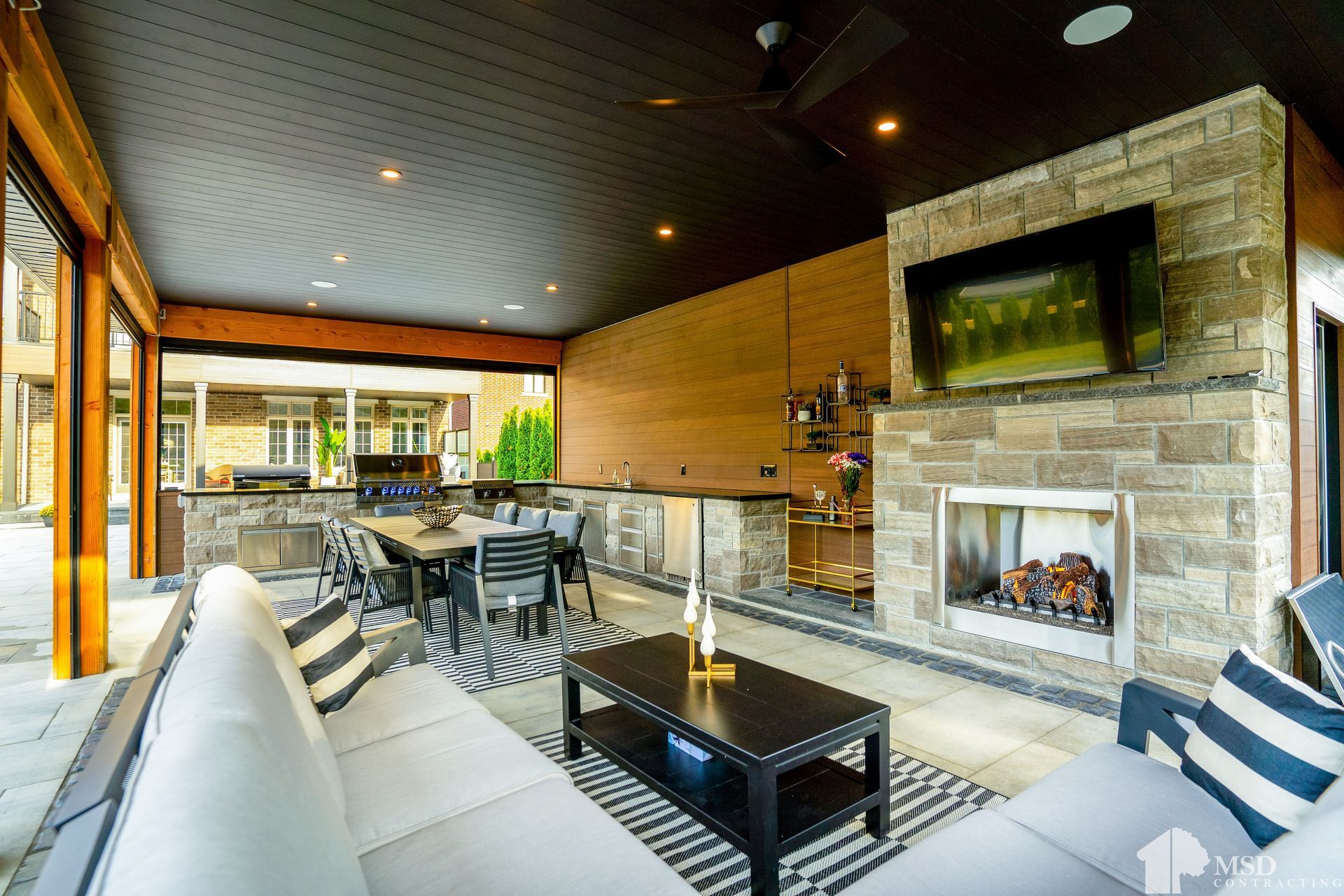 A living room with a couch, table, fireplace and television.