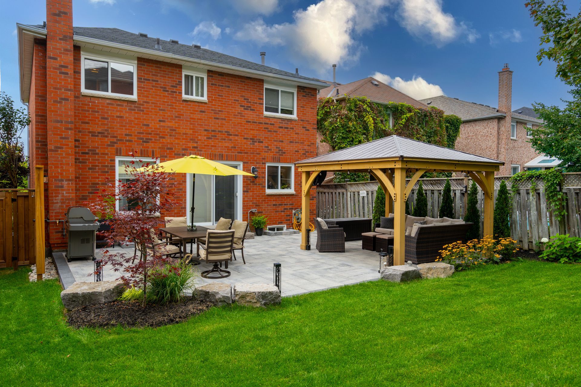 A brick house with a gazebo in the backyard