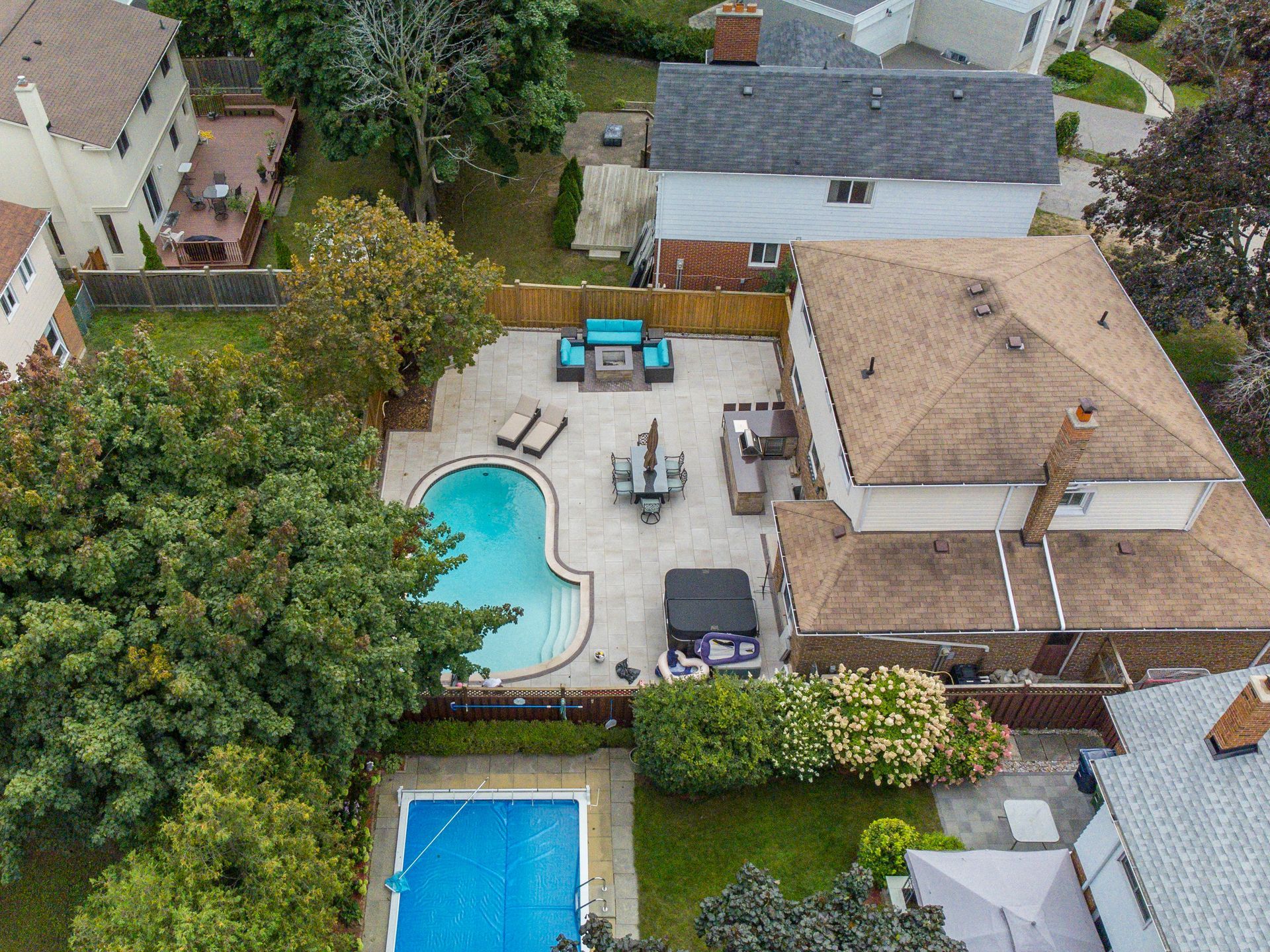 An aerial view of a house with a large swimming pool in the backyard.