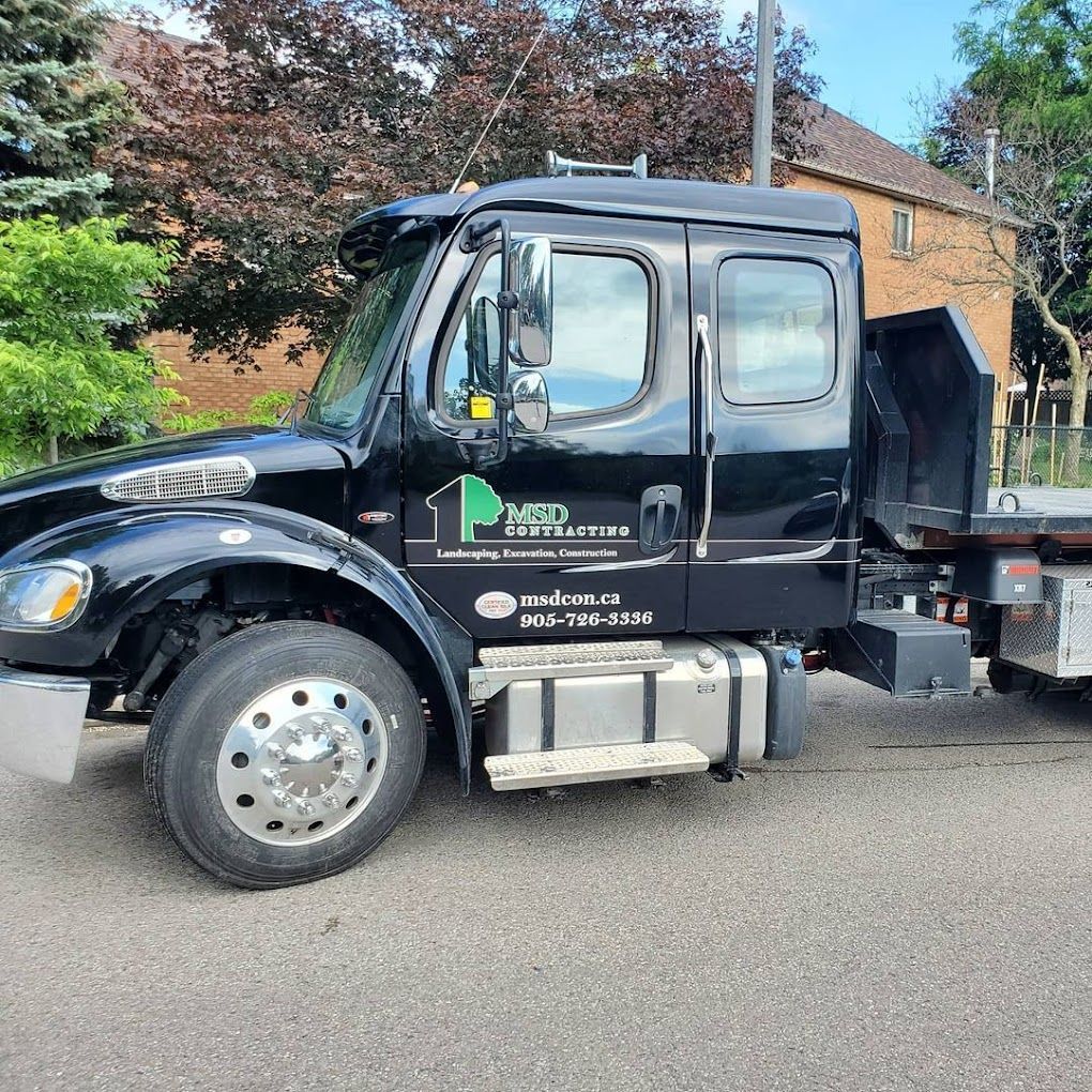 A black tow truck is parked on the side of the road.