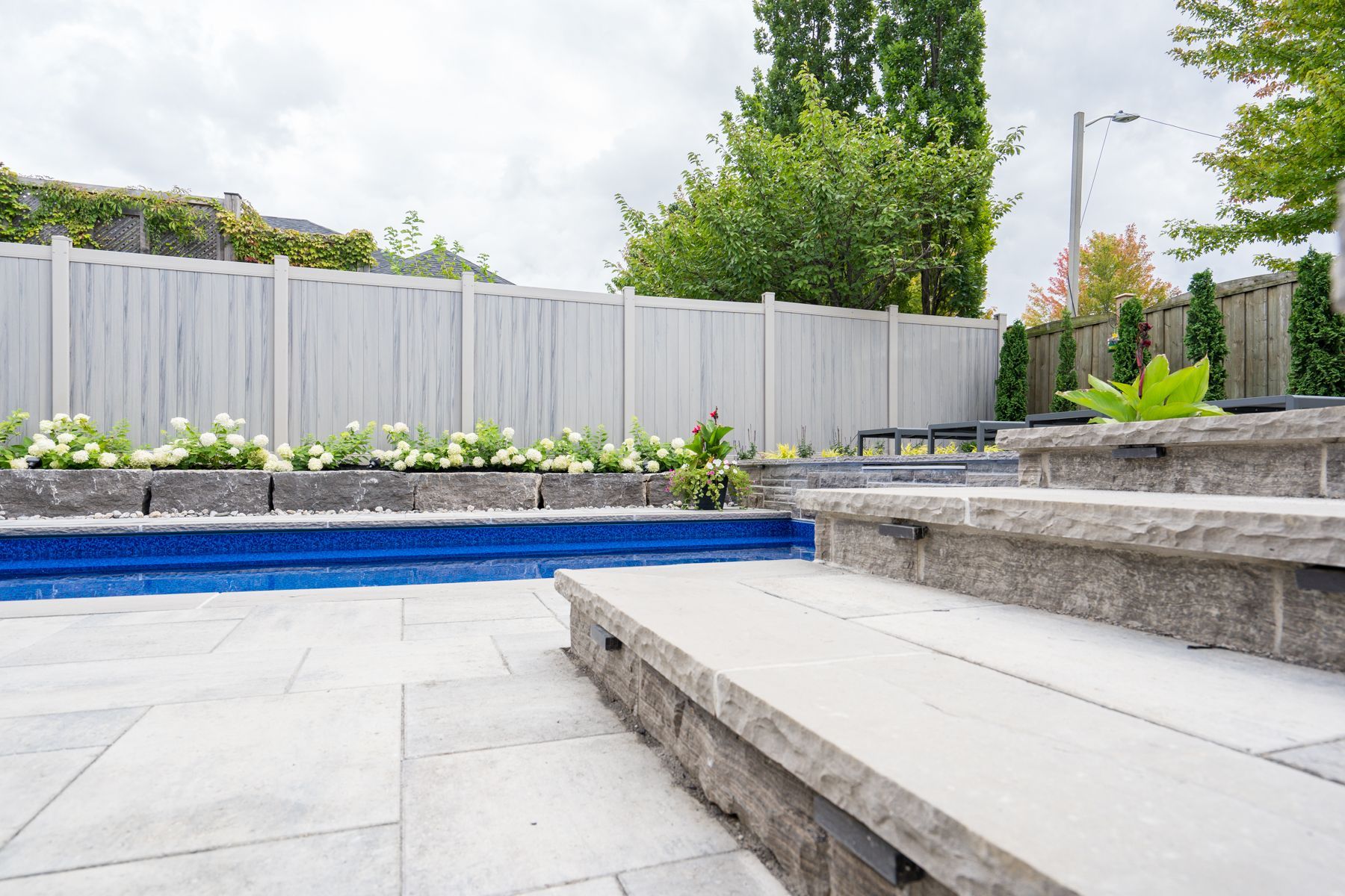 There is a swimming pool in the backyard with stairs leading up to it.