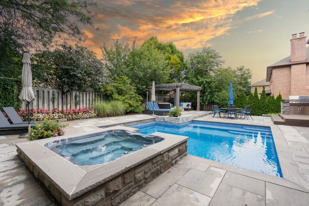 A swimming pool with a stone wall and a waterfall in the backyard.