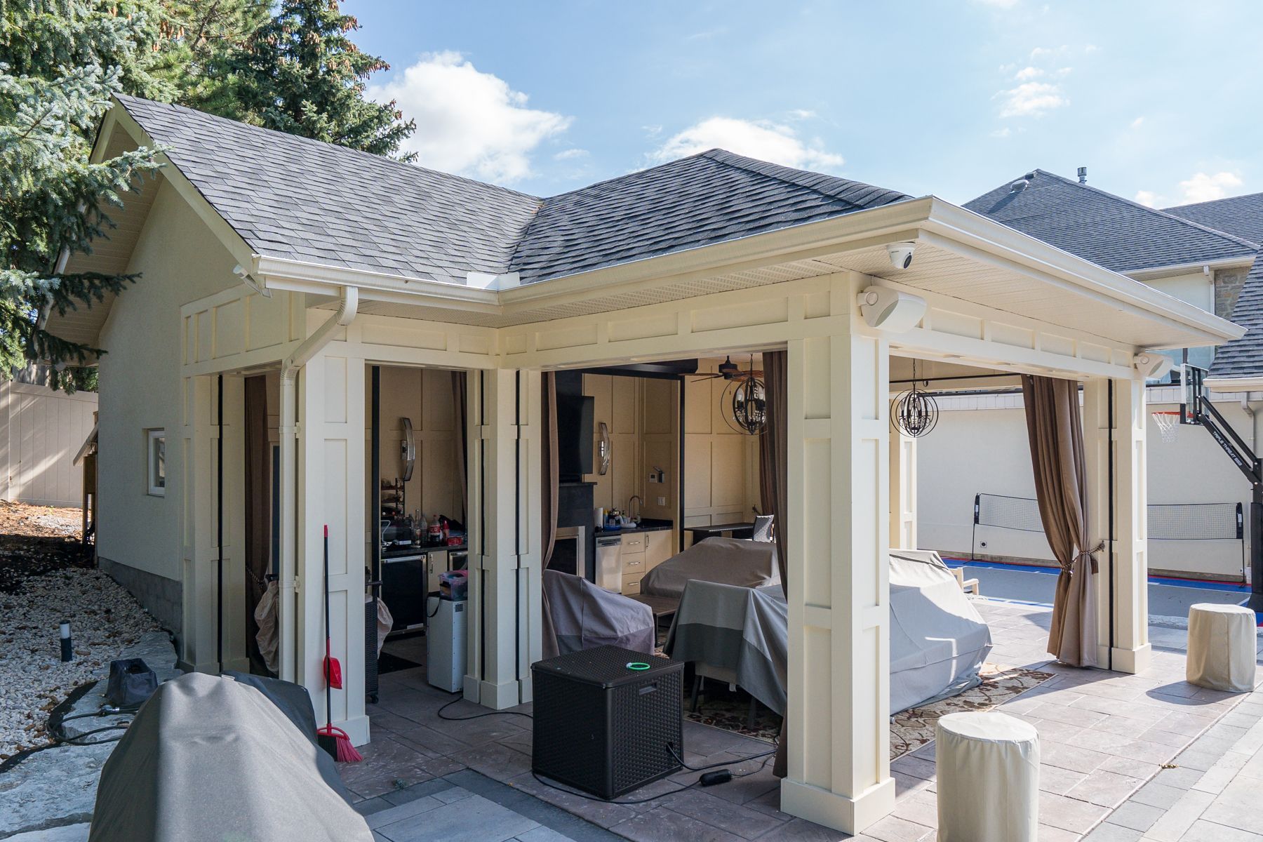 A white house with a large covered patio area in front of it.