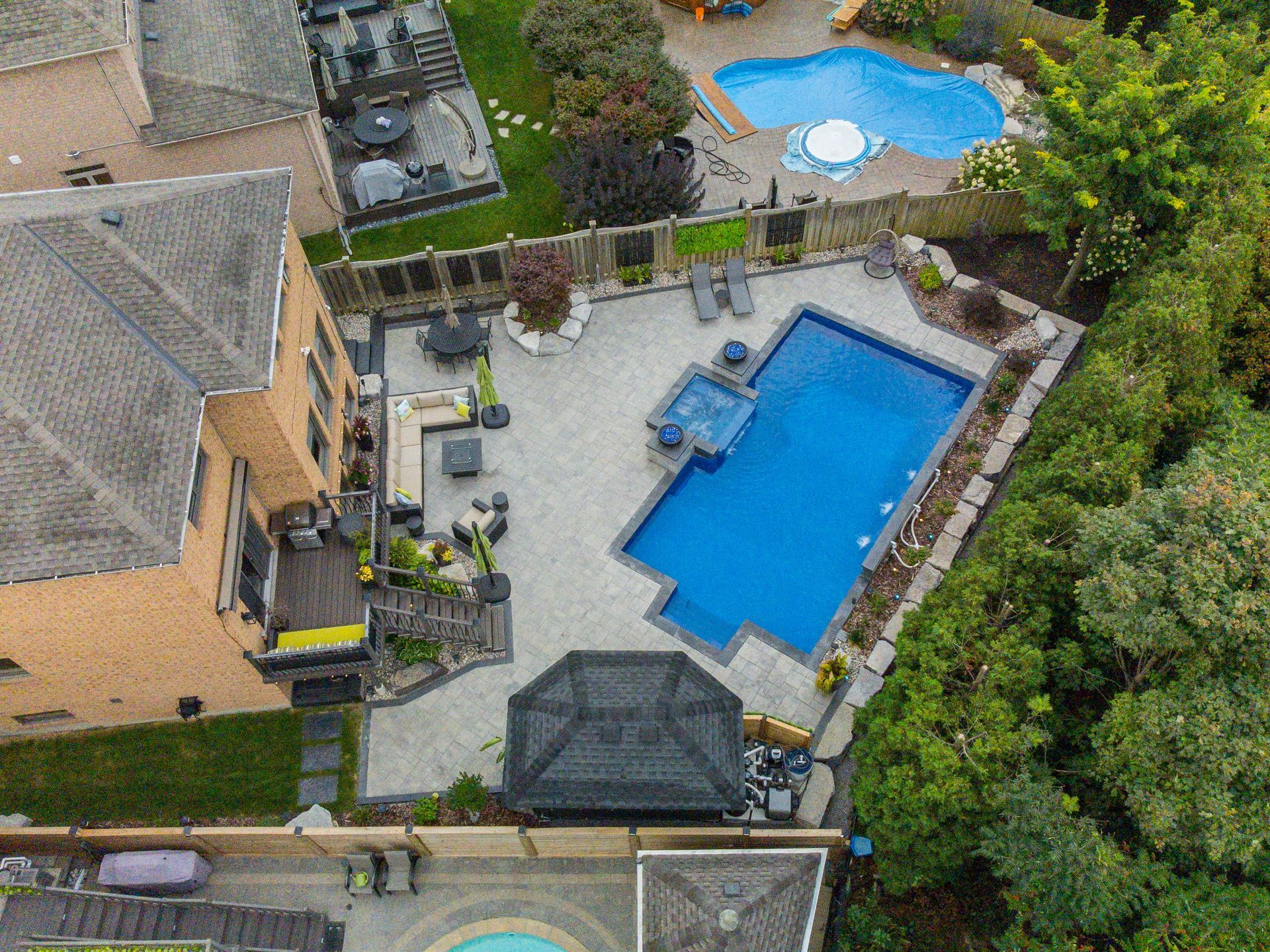 An aerial view of a house with a large swimming pool in the backyard.