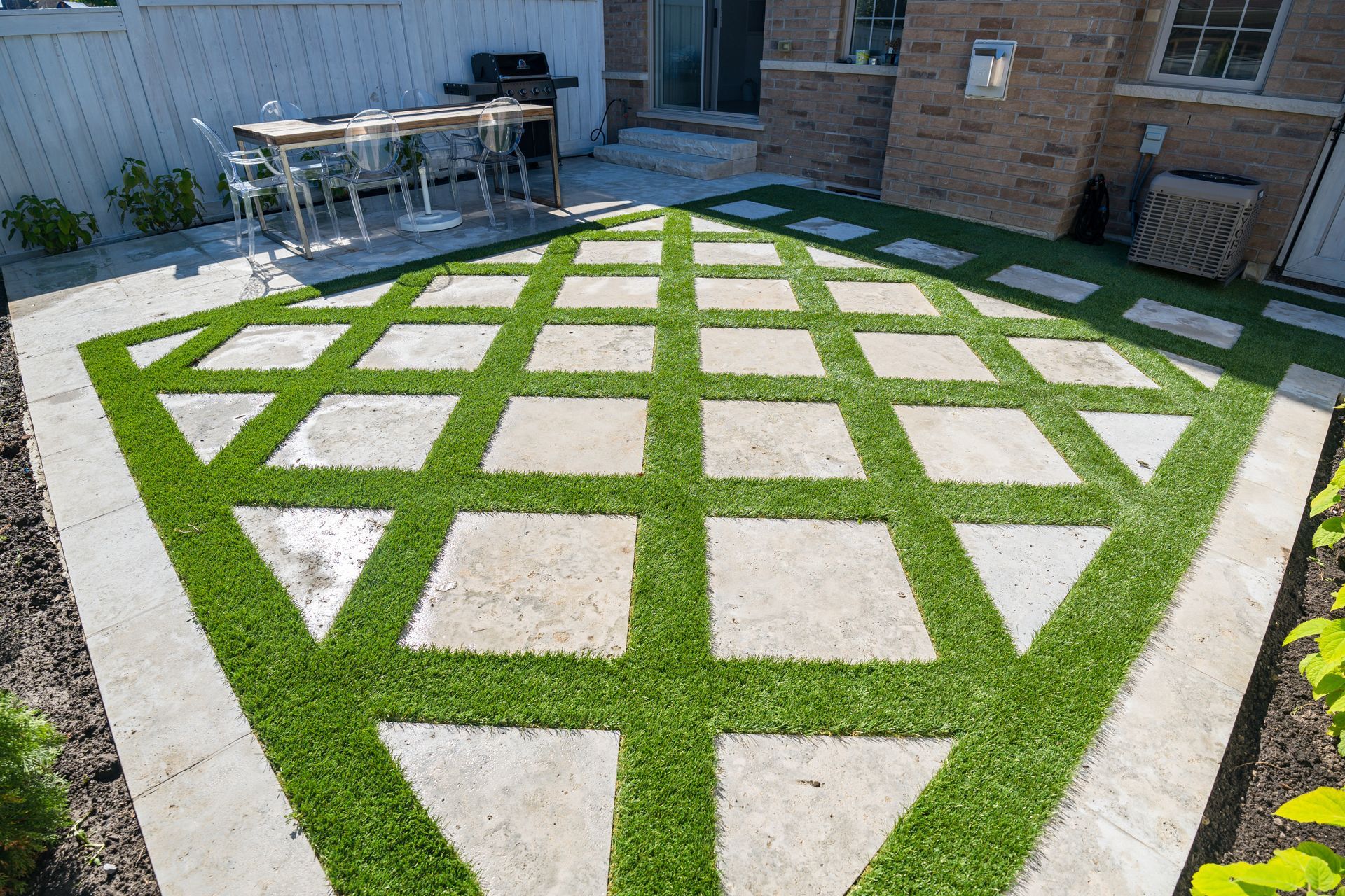 A backyard with a patio and a table and chairs.
