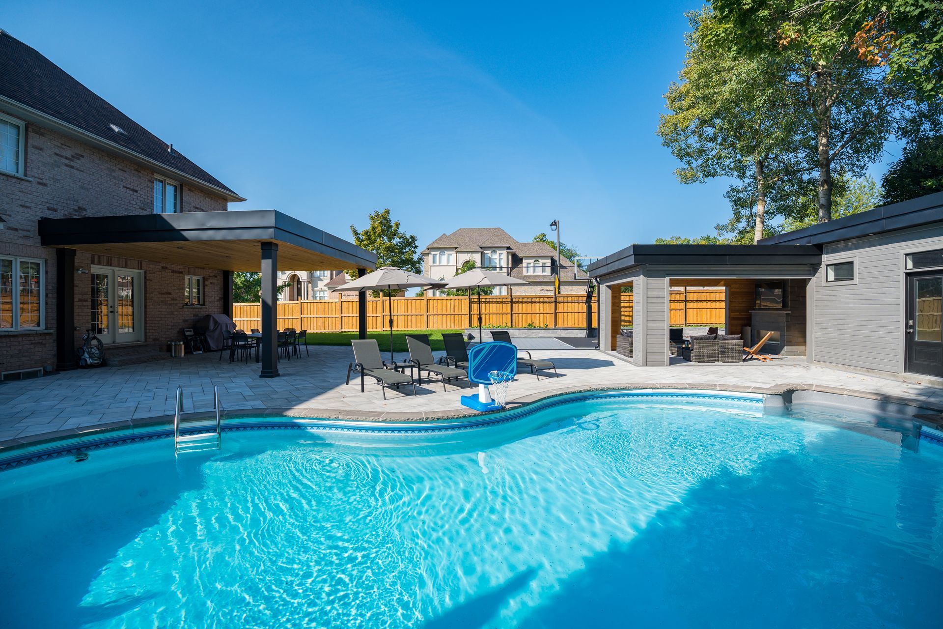 There is a large swimming pool in the backyard of a house.