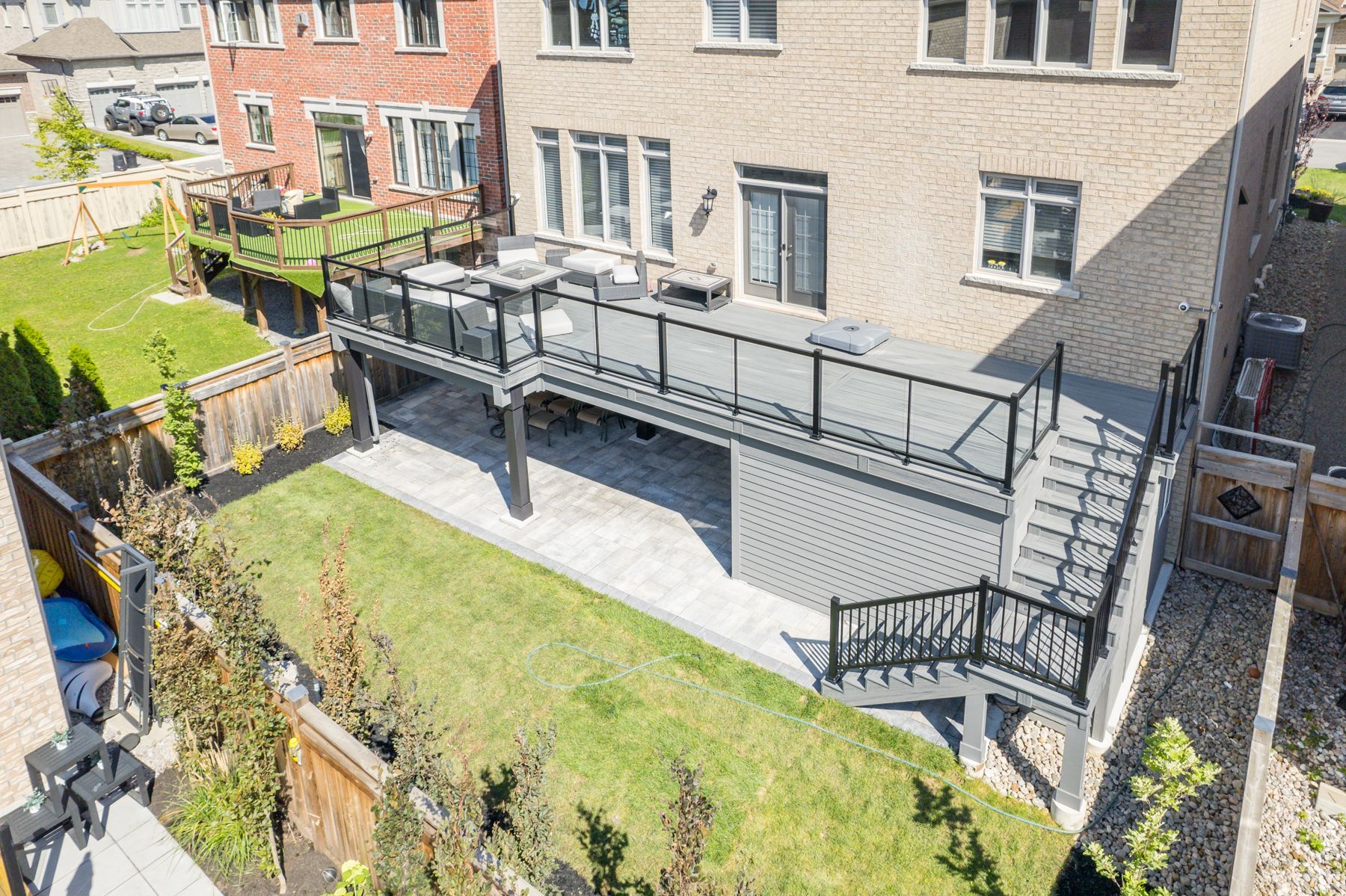 An aerial view of a house with a large deck in the backyard.