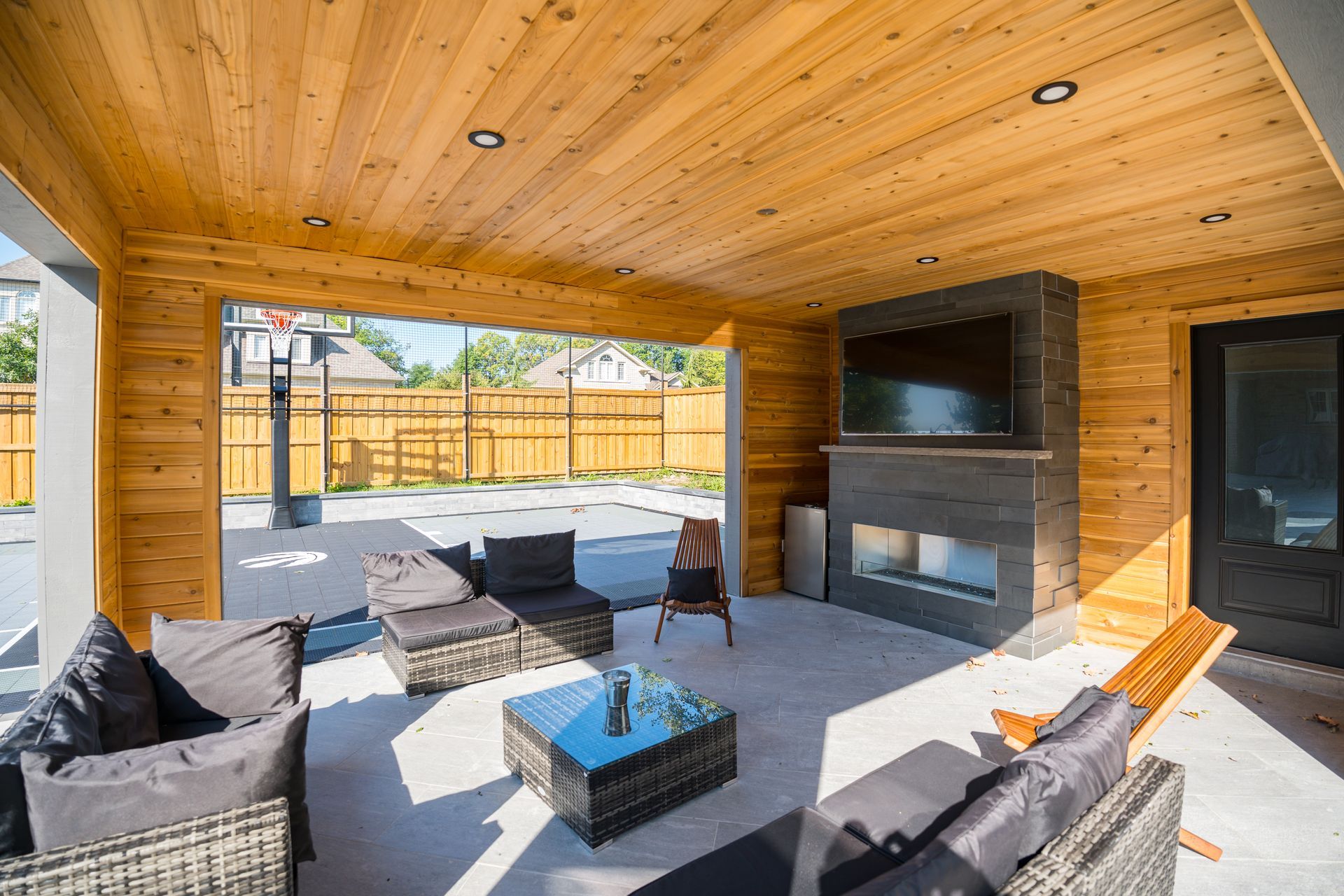 A patio with a fireplace and a flat screen tv.