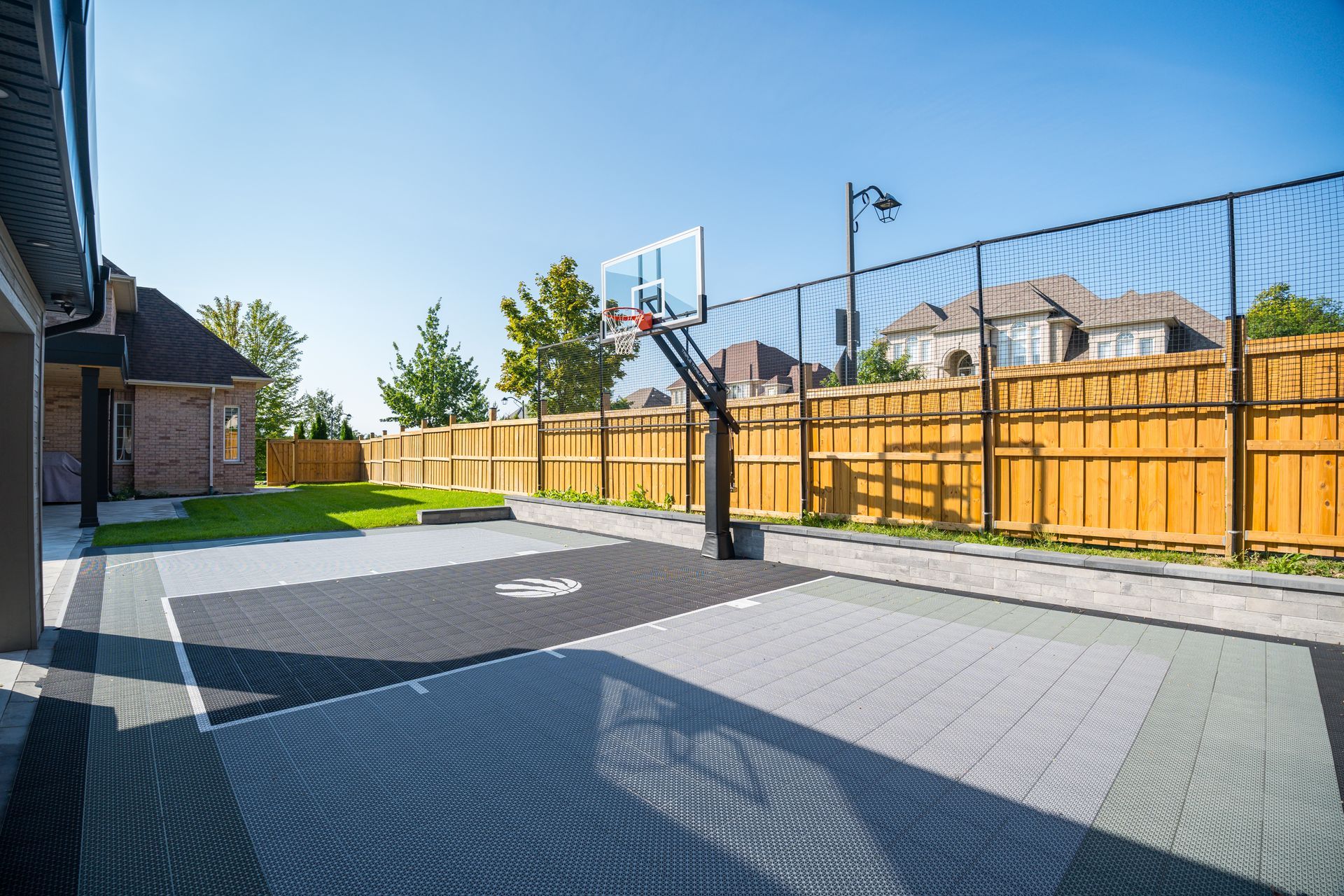 There is a basketball hoop in the backyard of a house.