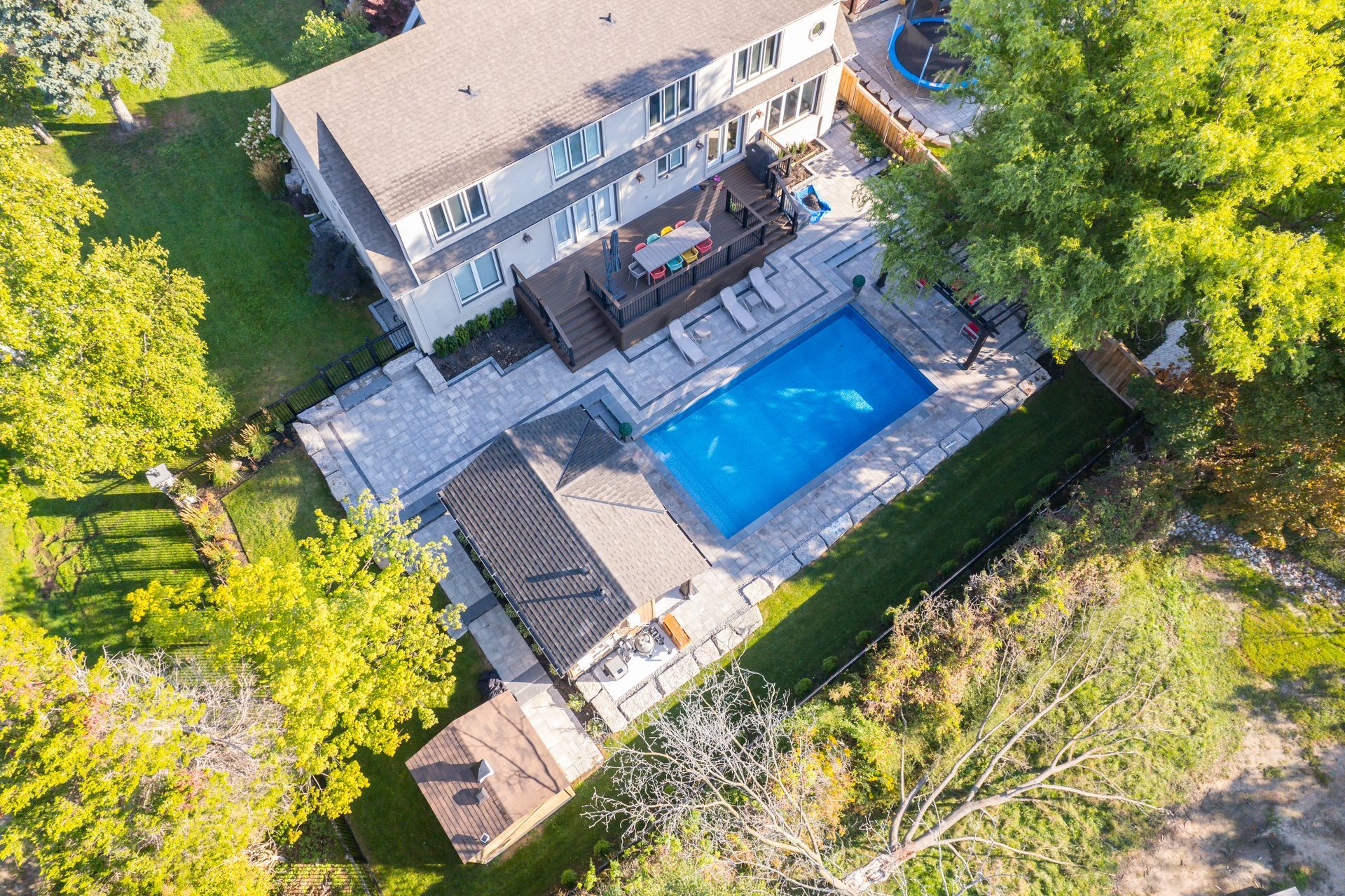 An aerial view of a house with a large swimming pool in the backyard.