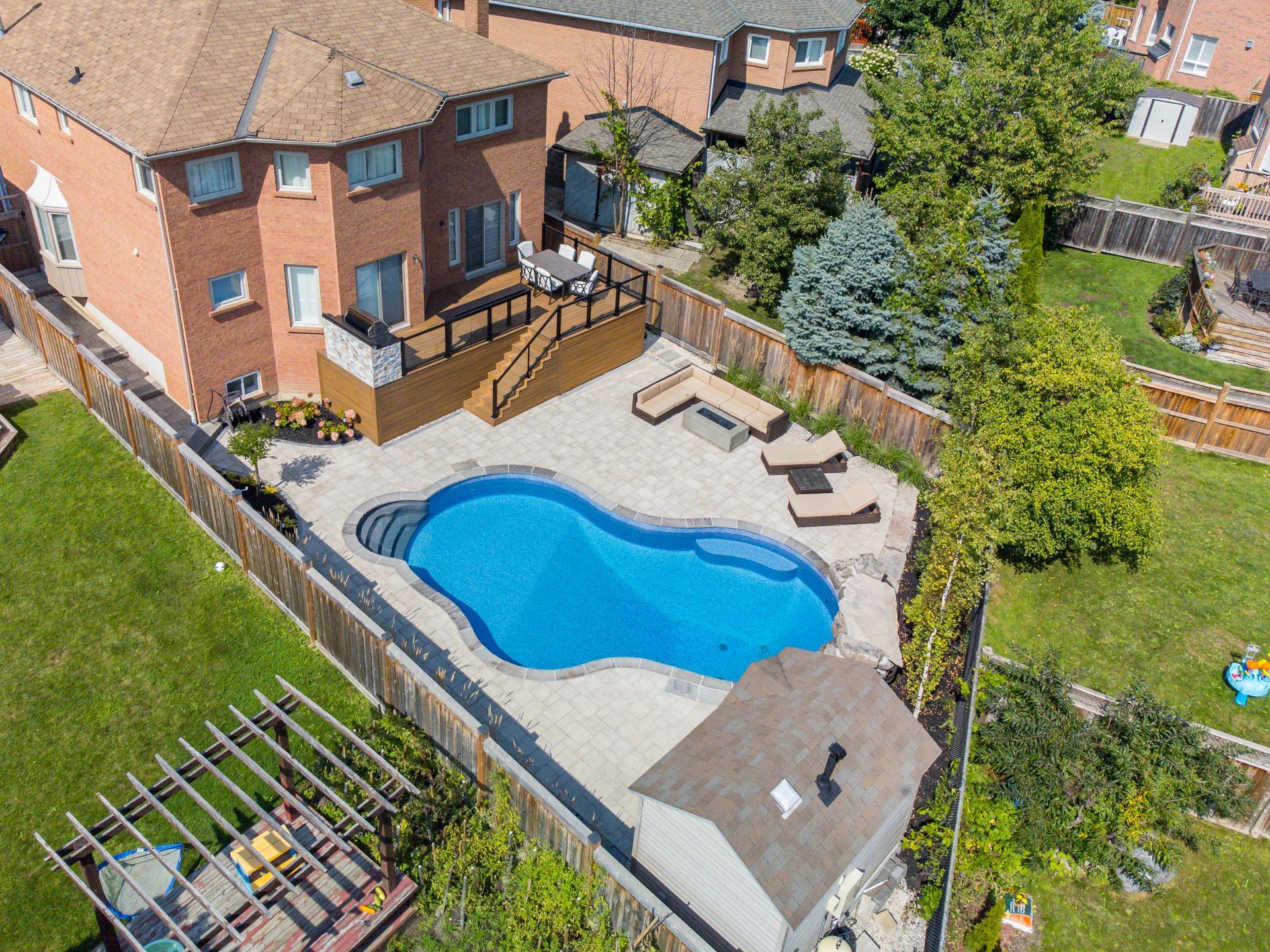 An aerial view of a house with a large swimming pool in the backyard.