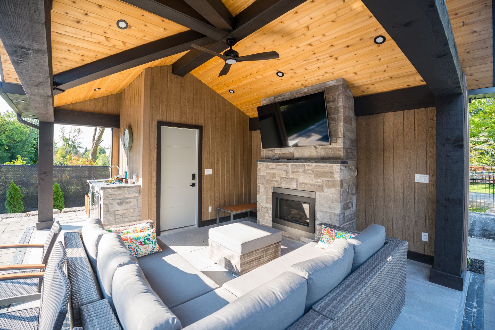 A living room with a couch , fireplace , television and ceiling fan.