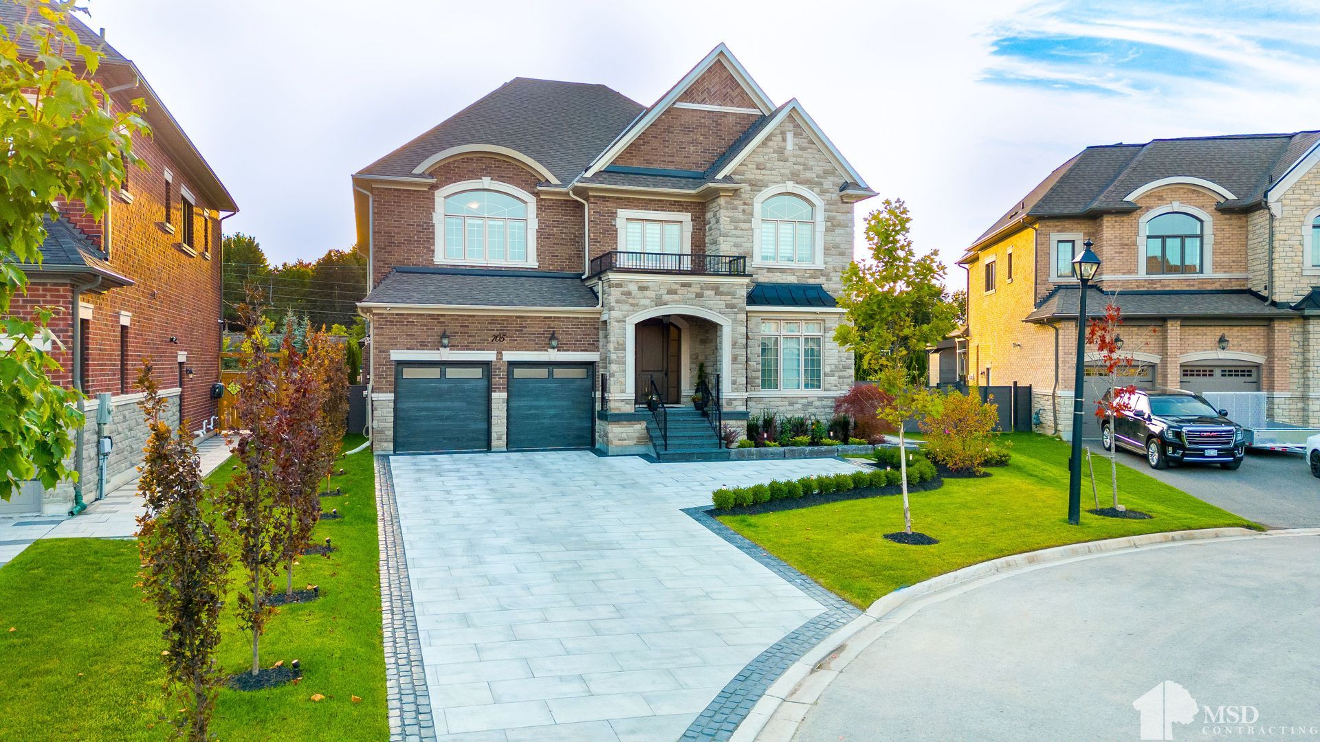 A large house is sitting on top of a lush green lawn in a residential neighborhood.