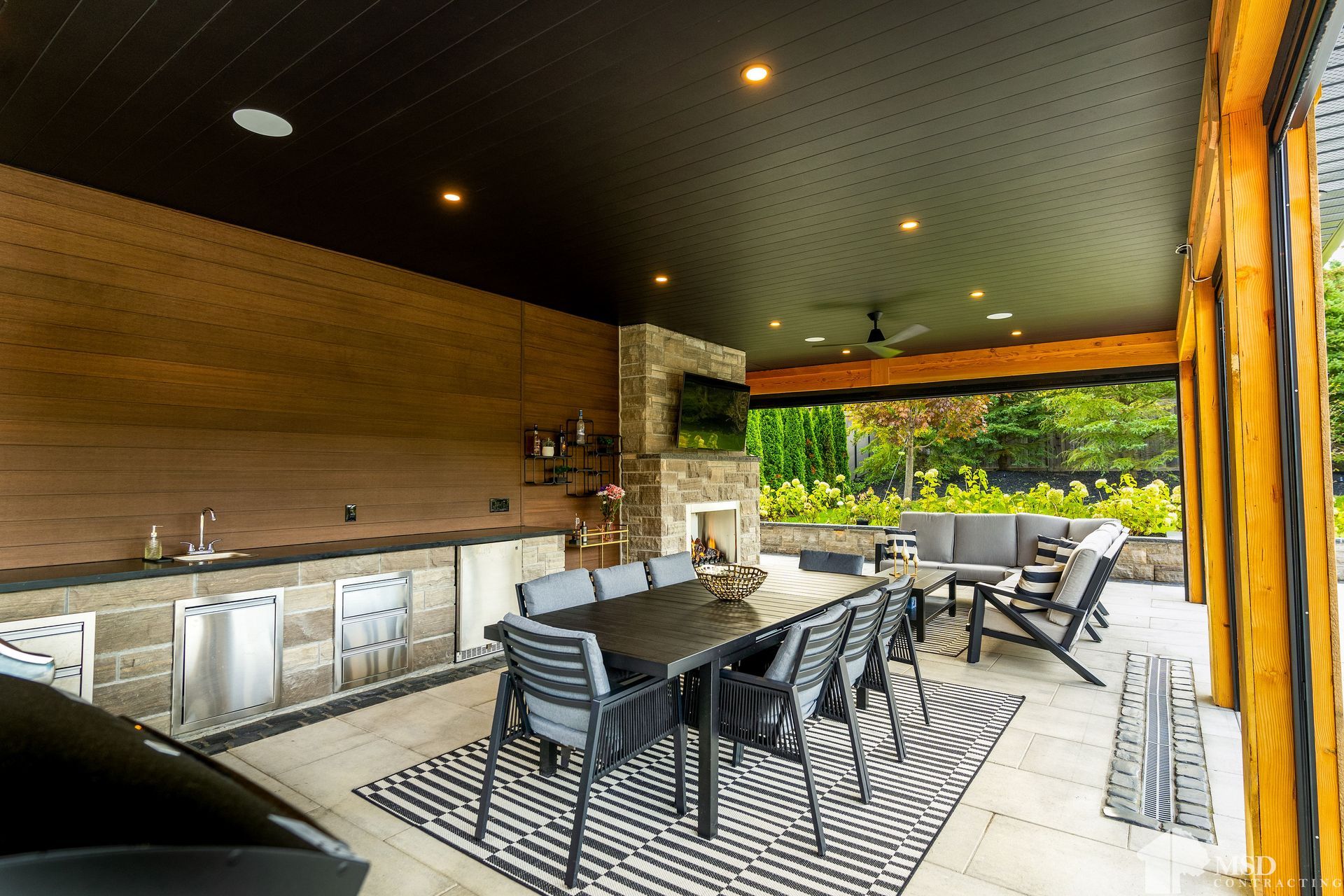 There is a table and chairs in the room with a black ceiling.