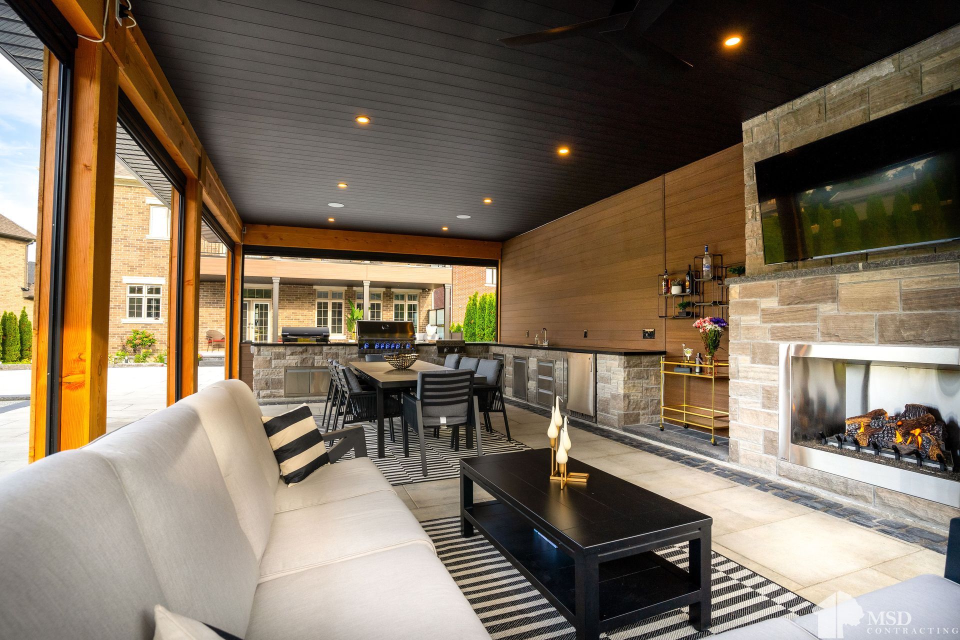 A living room with a couch , table , chairs and a fireplace.