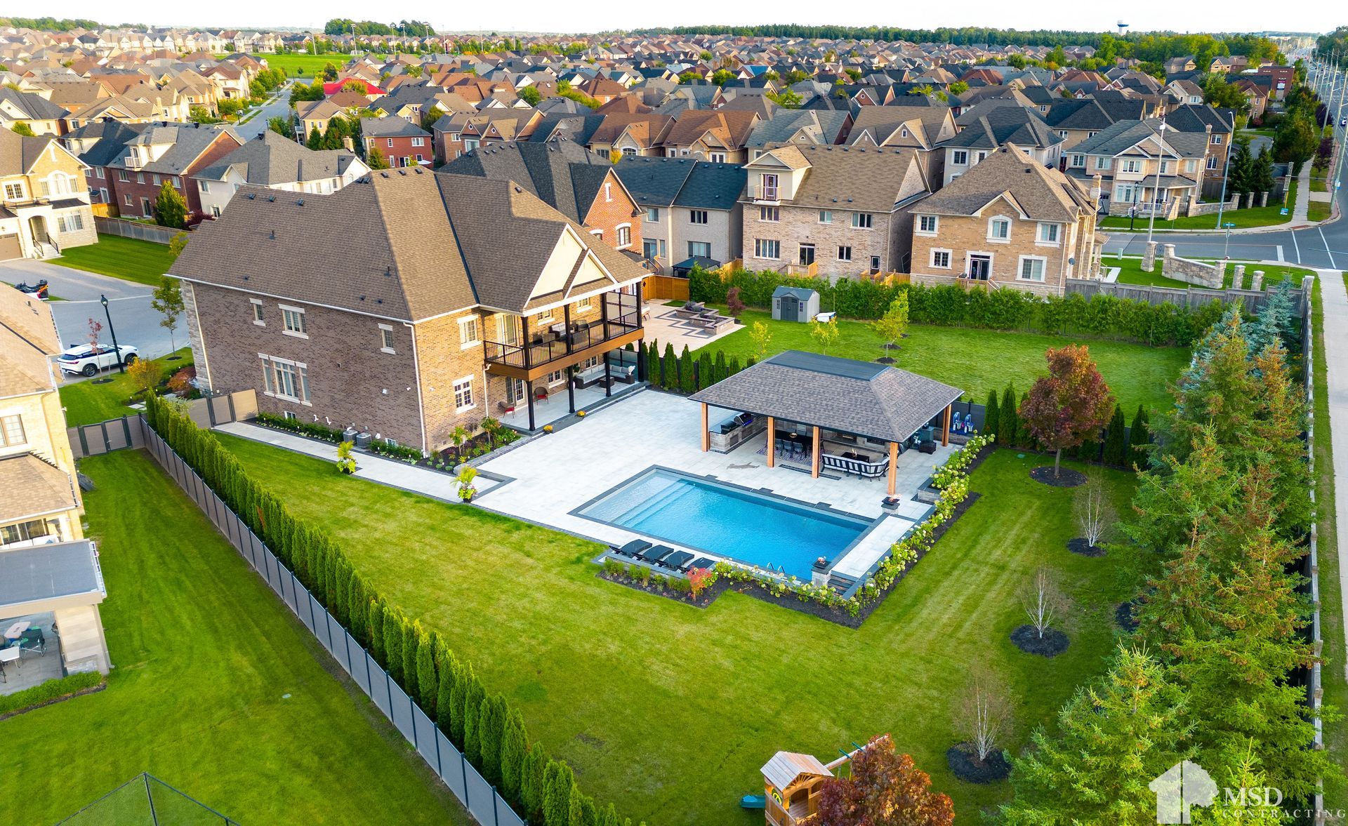 An aerial view of a house with a large pool in the backyard.